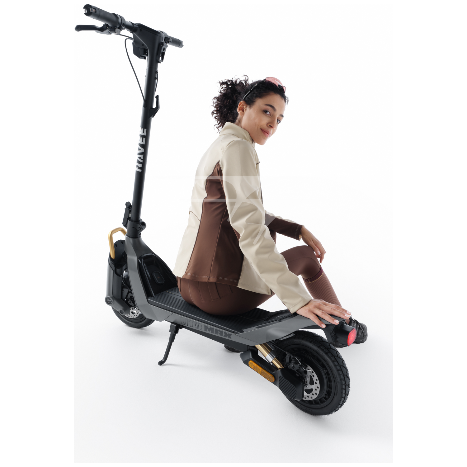 Een vrouw zit op een elektrische scooter tegen een witte achtergrond.