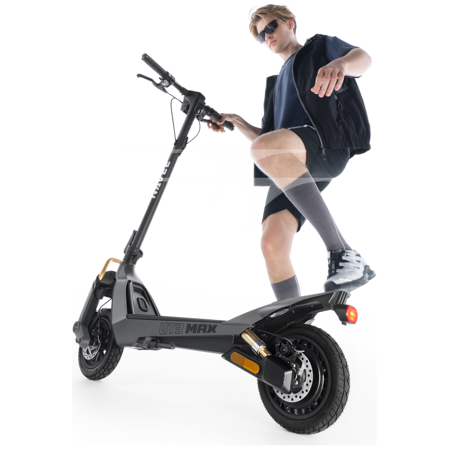 Een man in korte broek en vest stapt op een grijze elektrische scooter.