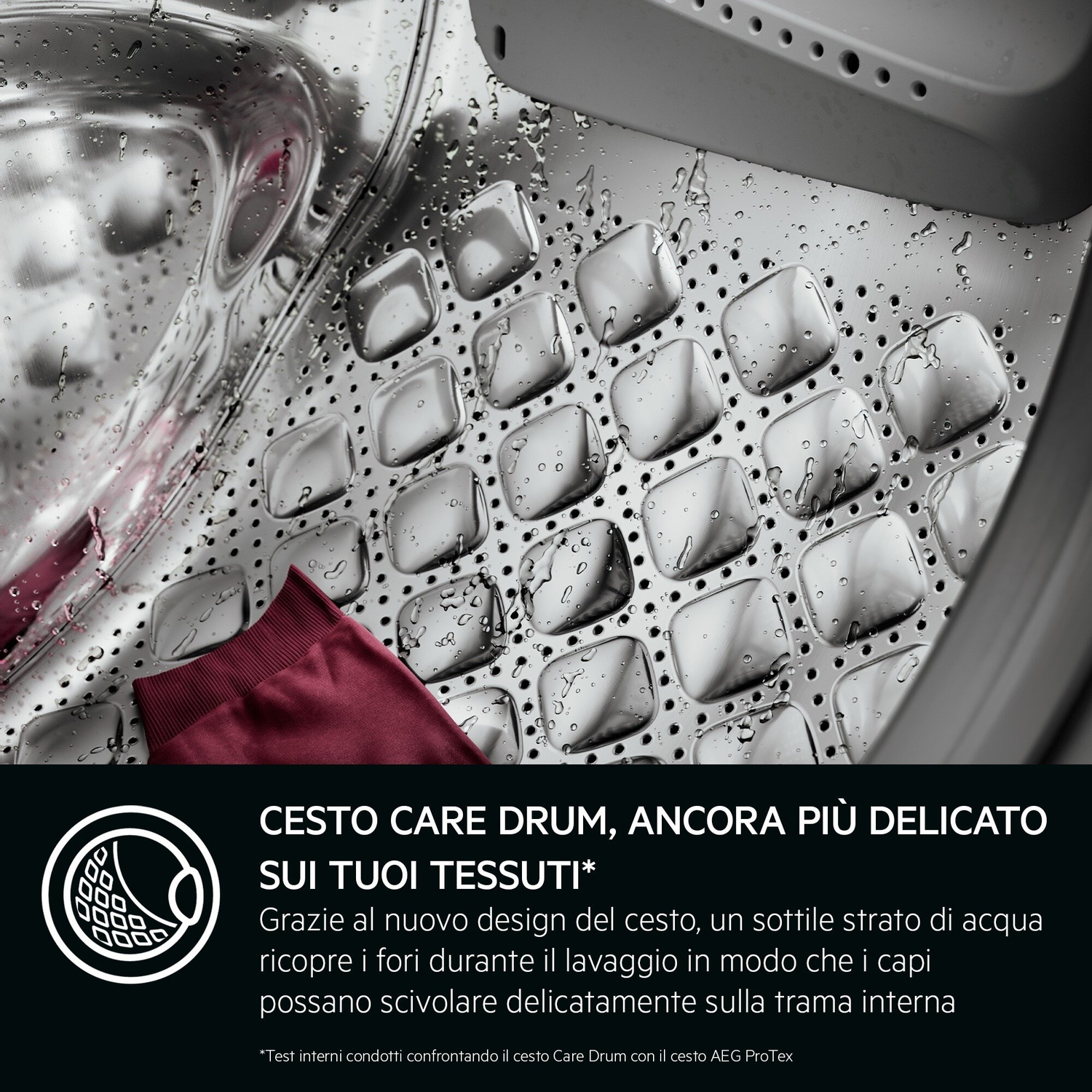 Interno di un cestello di lavatrice con acqua e un capo rosso.