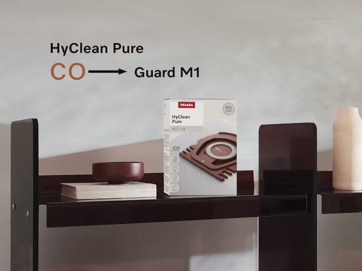 Opakowanie Miele HyClean Pure CO Guard M1 na półce z dekoracjami.