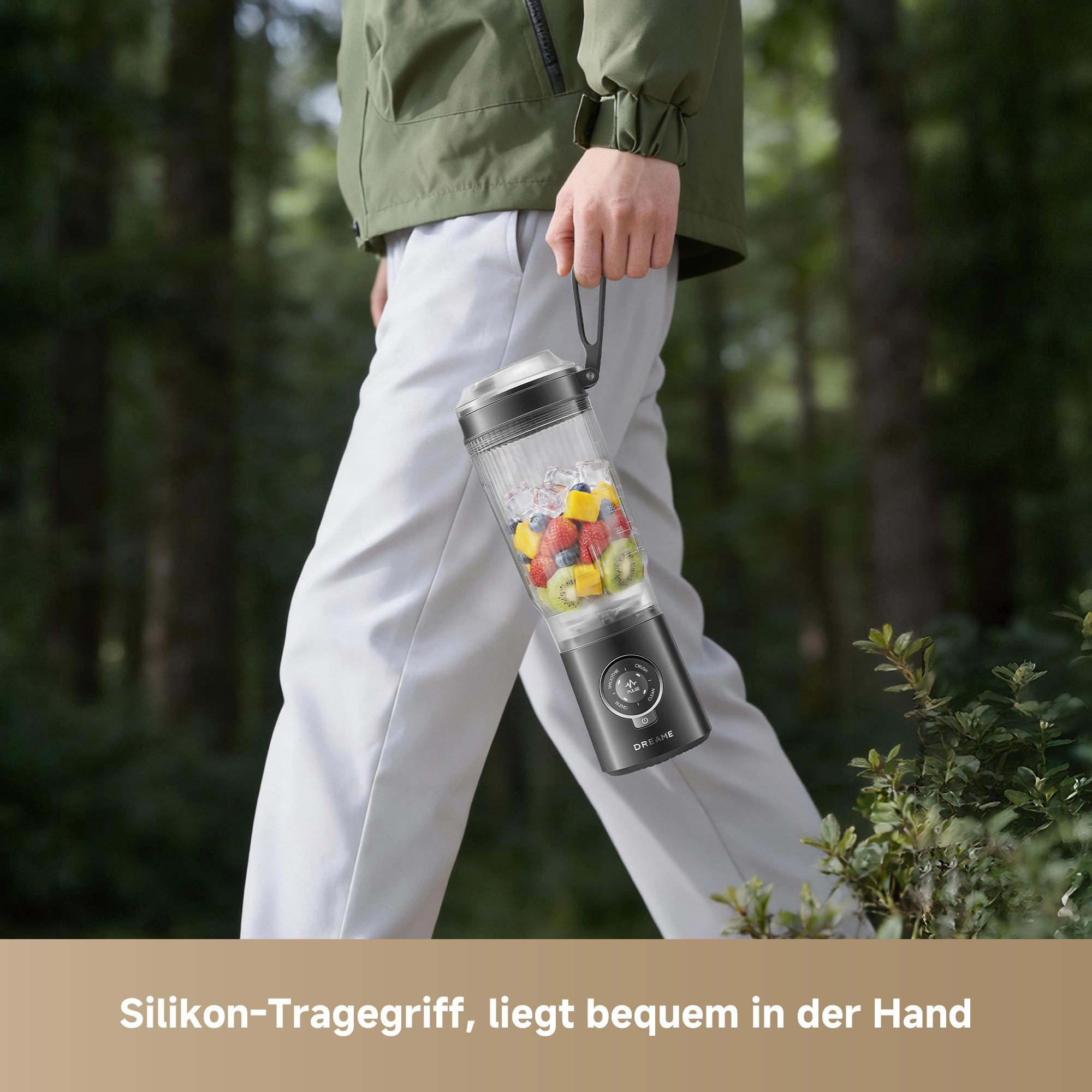 Person hält tragbaren Mixer mit Früchten und Eis im Wald.