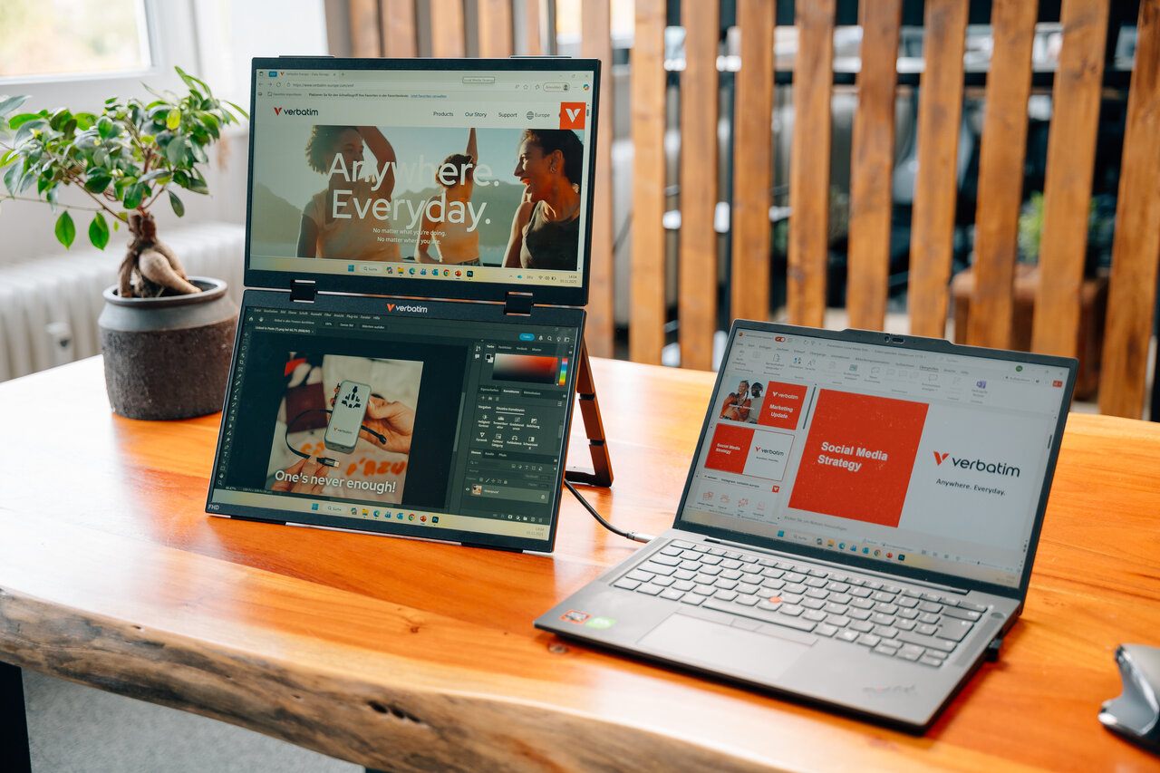 Zwei Laptops auf einem Holztisch. Einer zeigt eine Website, der andere eine Präsentation.