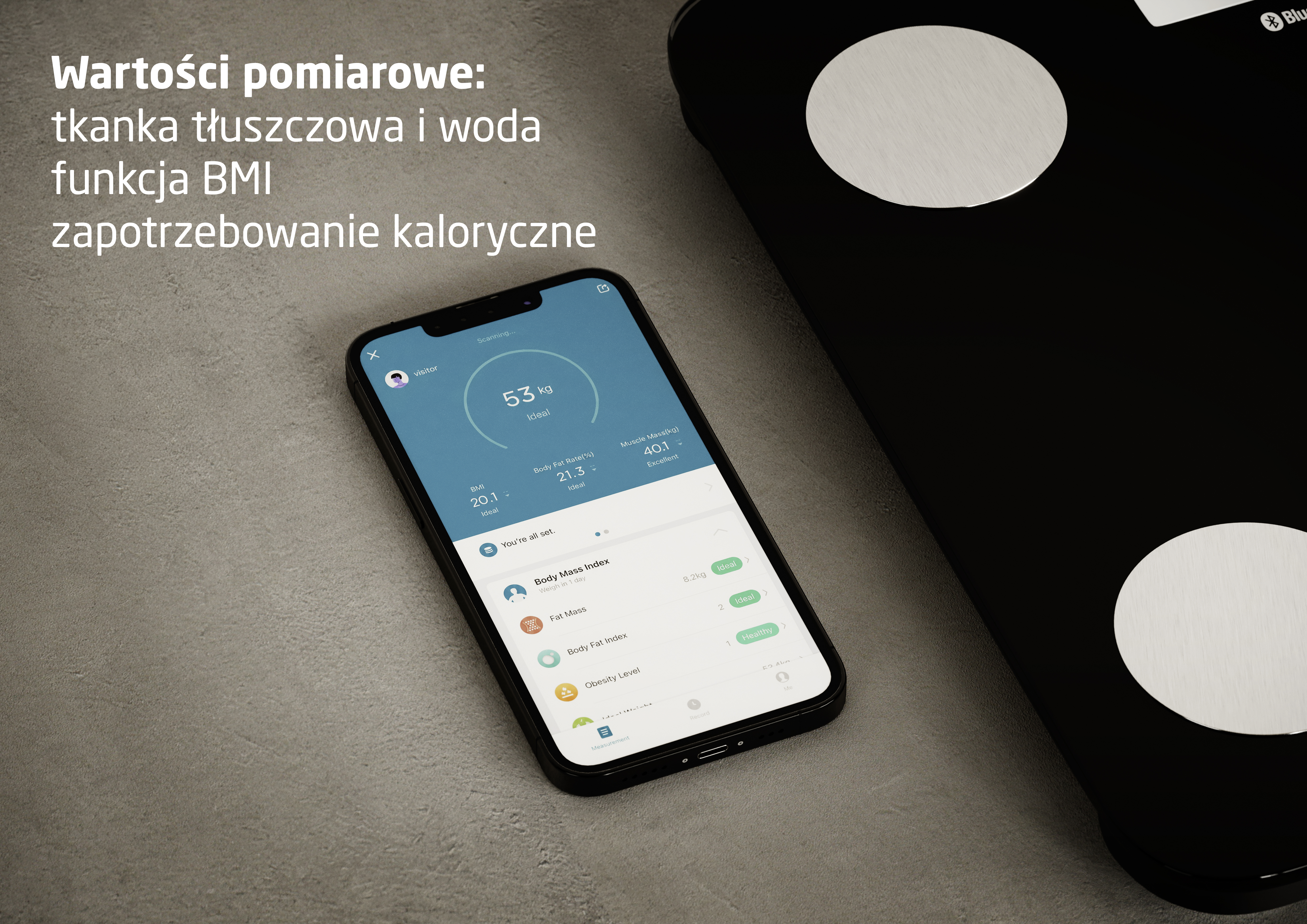 Smartfon wyświetla dane zdrowotne jak waga i BMI, obok wagi łazienkowej.