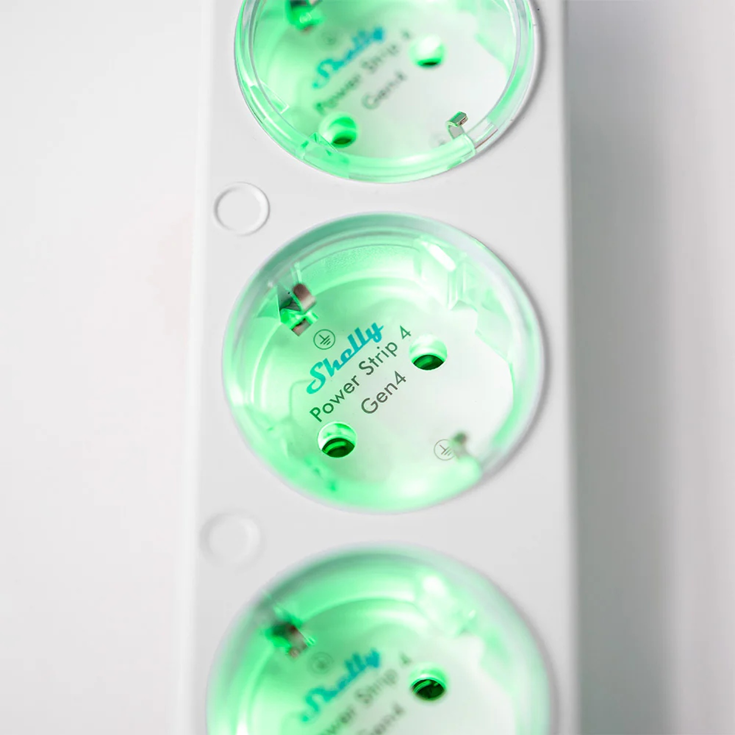 Tre ciabatte con illuminazione verde e etichetta Shelly Power Strip 4 Gen4.