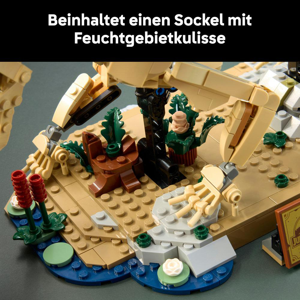 Ein gelber Baggerarm über einer Lego-Landschaft mit Pflanzen.