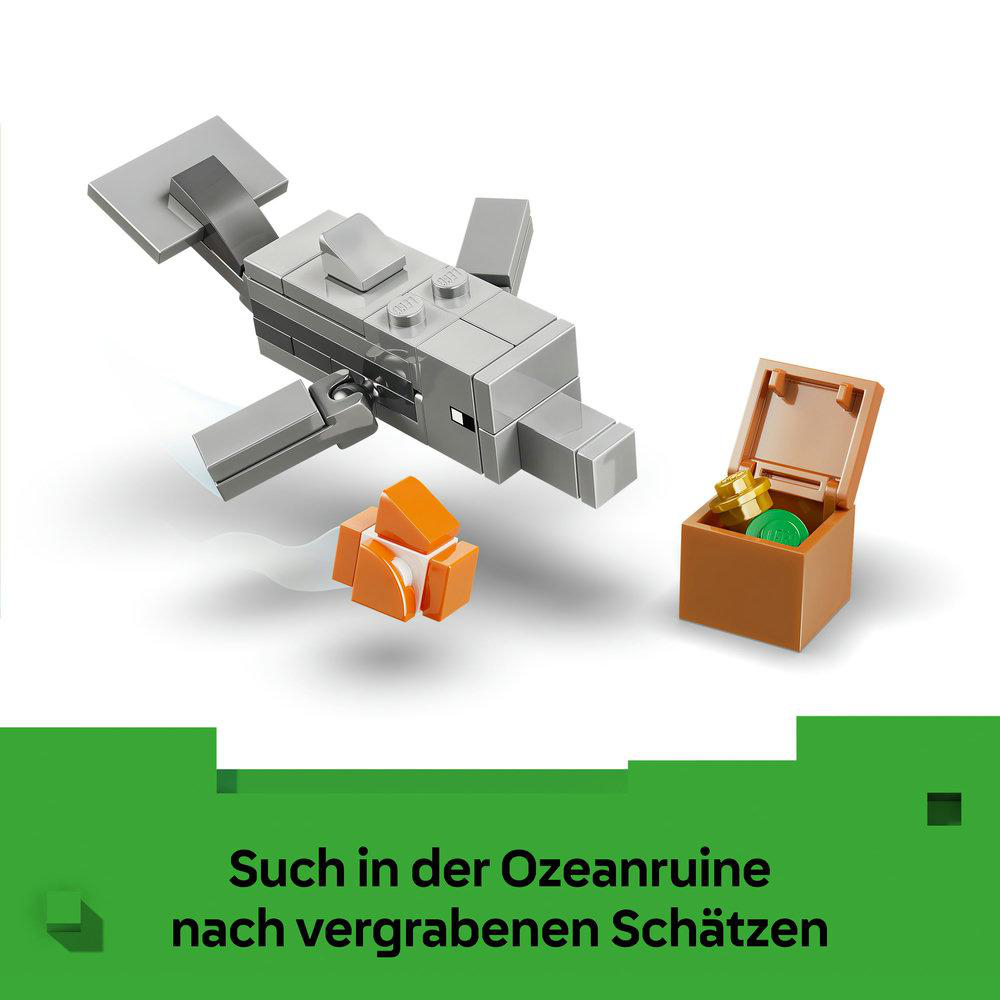 Grauer Lego-Delfin neben orangefarbenen Teilen und einer offenen Schatzkiste mit Gold.