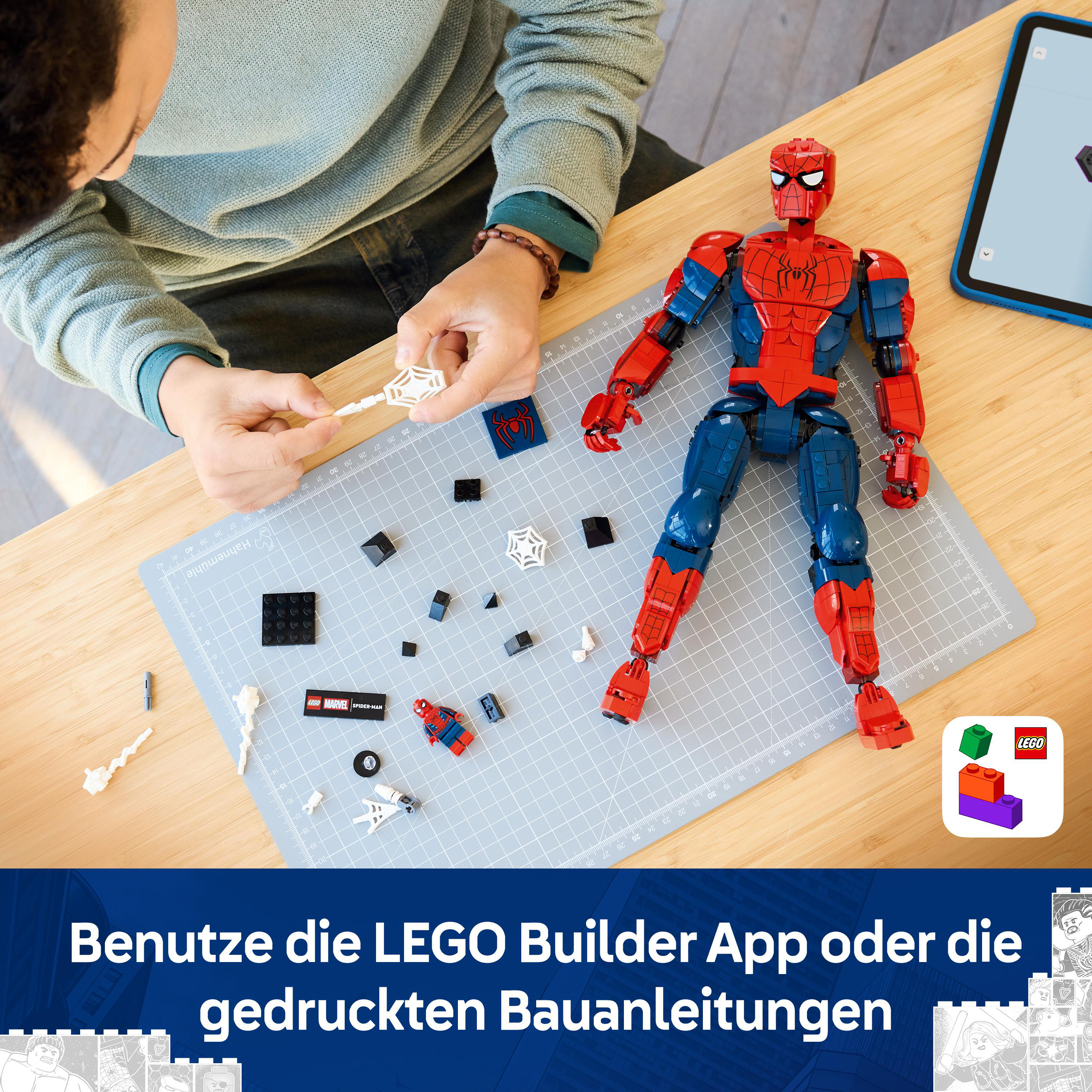 Ein Kind baut einen roten und blauen Spiderman LEGO-Bausatz mit einer Anleitung auf einem Tisch.