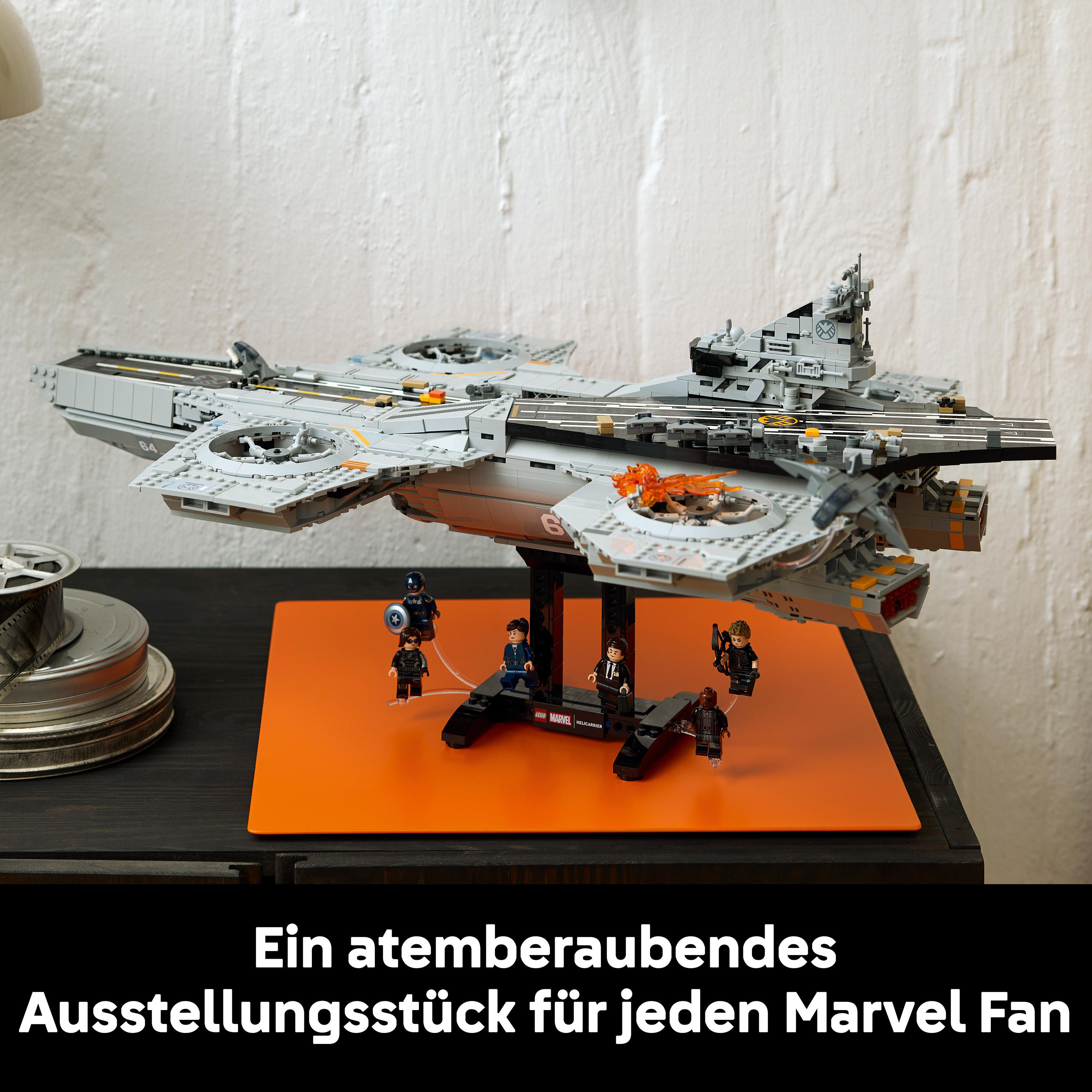 Grauer Lego-Helicarrier mit Marvel-Figuren auf orangefarbener Unterlage.