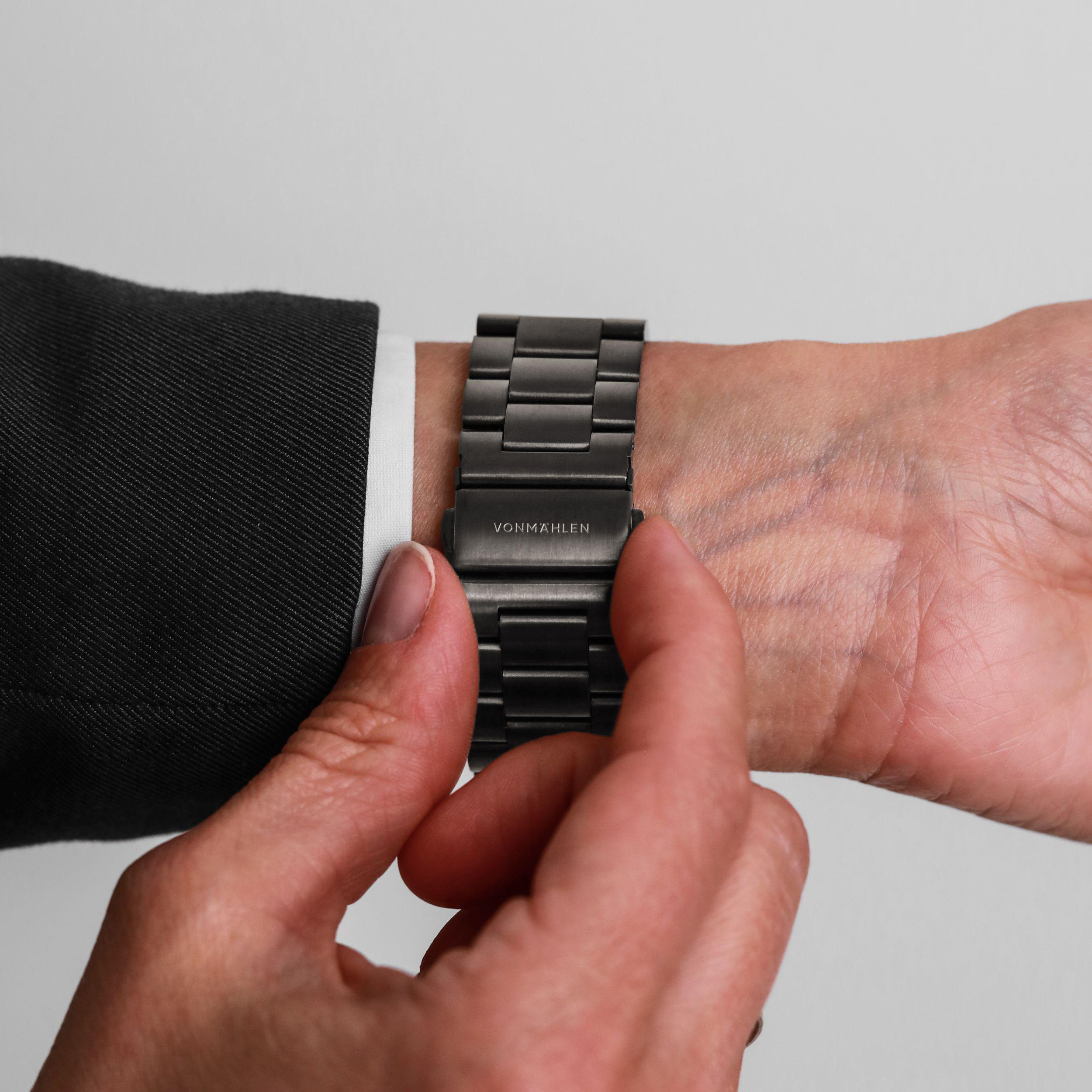 Graues Metallarmband einer Uhr, das an einem Handgelenk befestigt wird. Der Schriftzug VONMAHLEN ist sichtbar.
