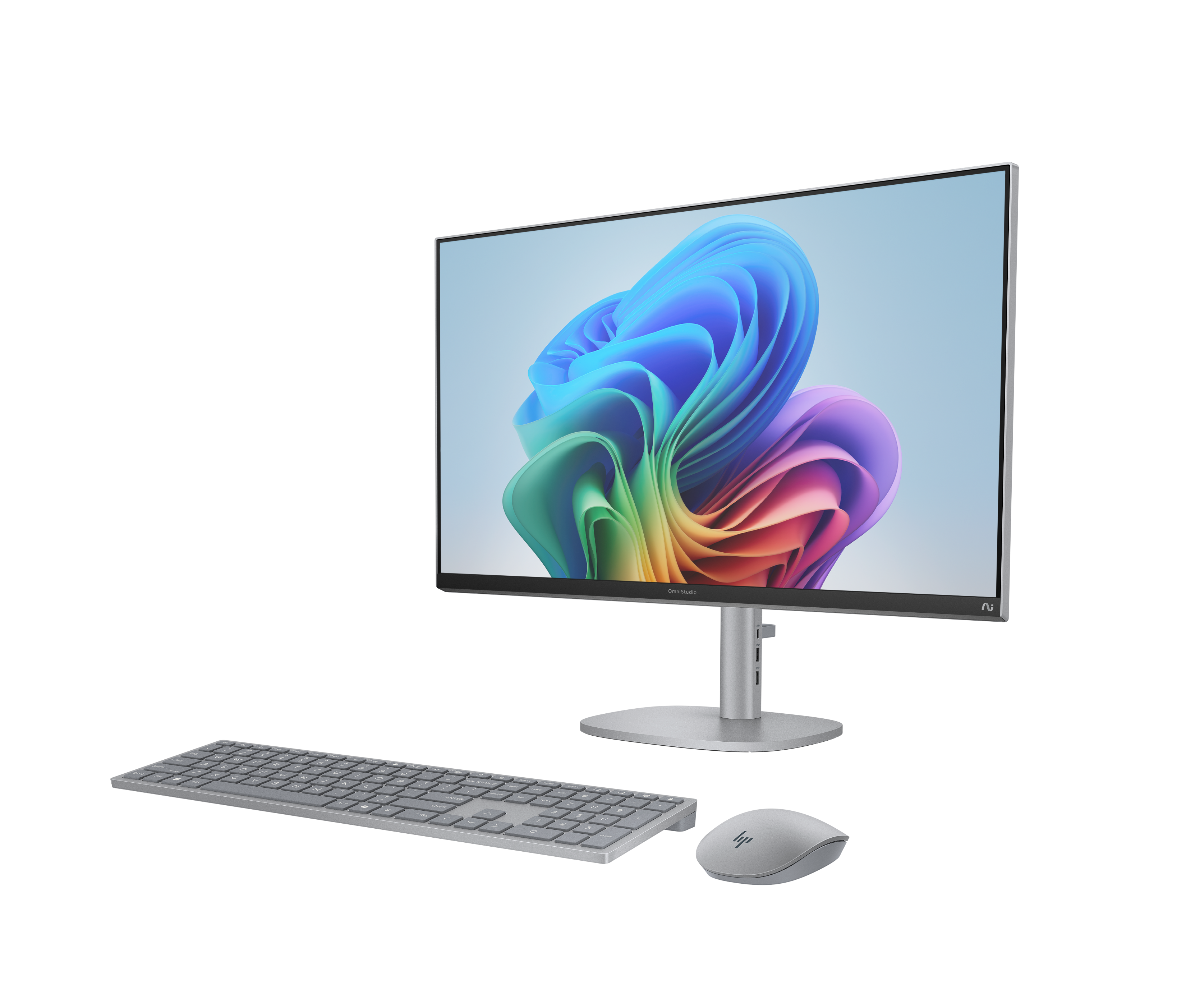 Een zilveren computermonitor met kleurrijke achtergrond, toetsenbord en muis.