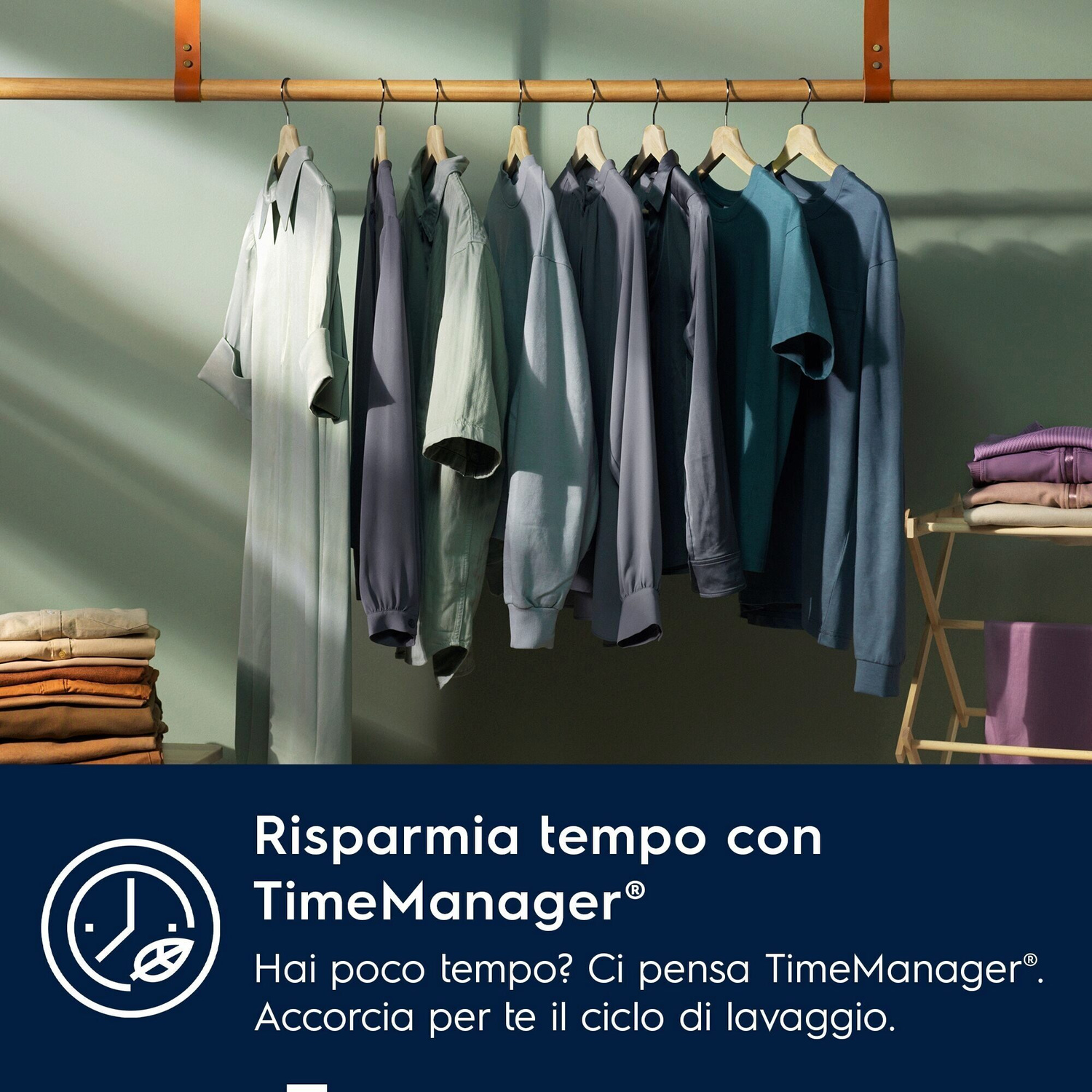 Vestiti appesi a una barra; pile di vestiti accanto.