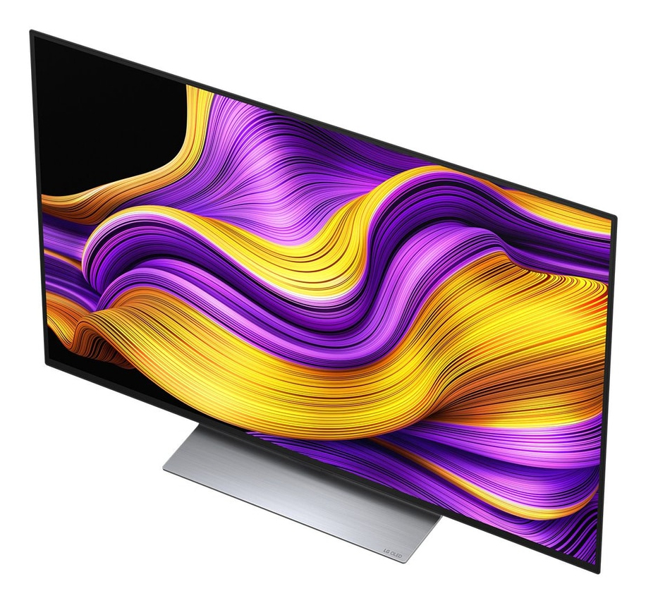 Un televisor moderno que muestra un patrón ondulado y colorido en la pantalla, con un soporte plateado.