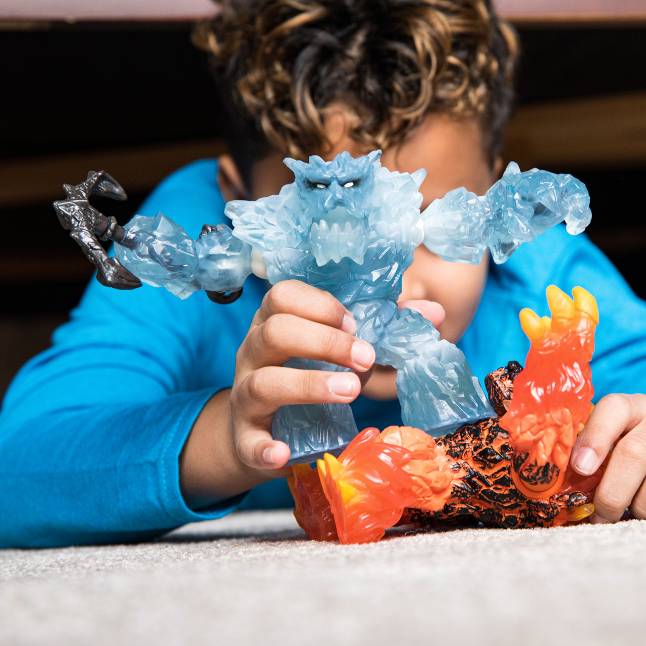Ein Kind spielt mit zwei Actionfiguren: eine aus Eis, eine aus Feuer.