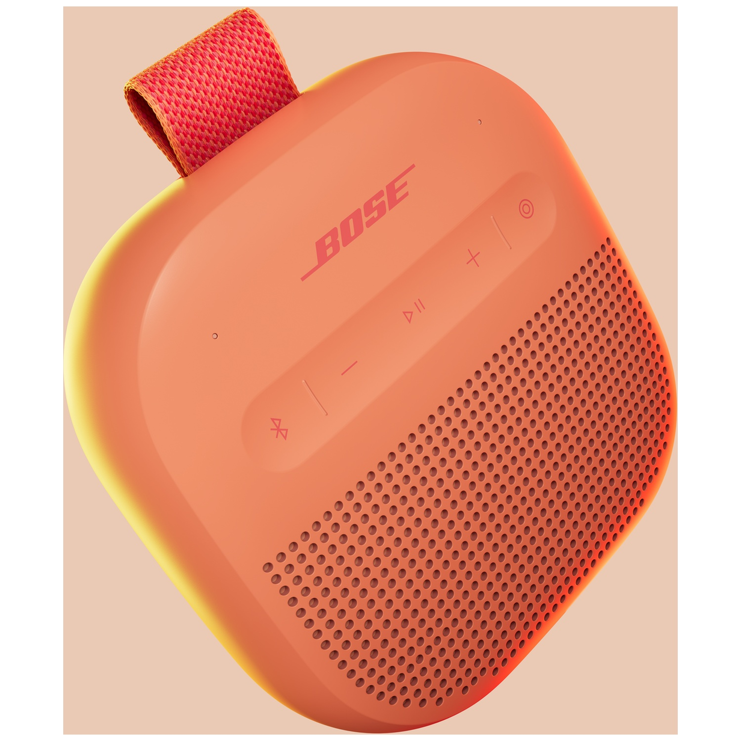 Een oranje Bose speaker met rode lus en bedieningsknoppen op lichte achtergrond.