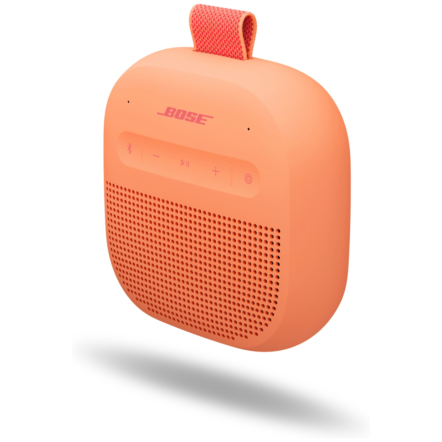 Een koraalkleurige Bose speaker met band en bedieningsknoppen.