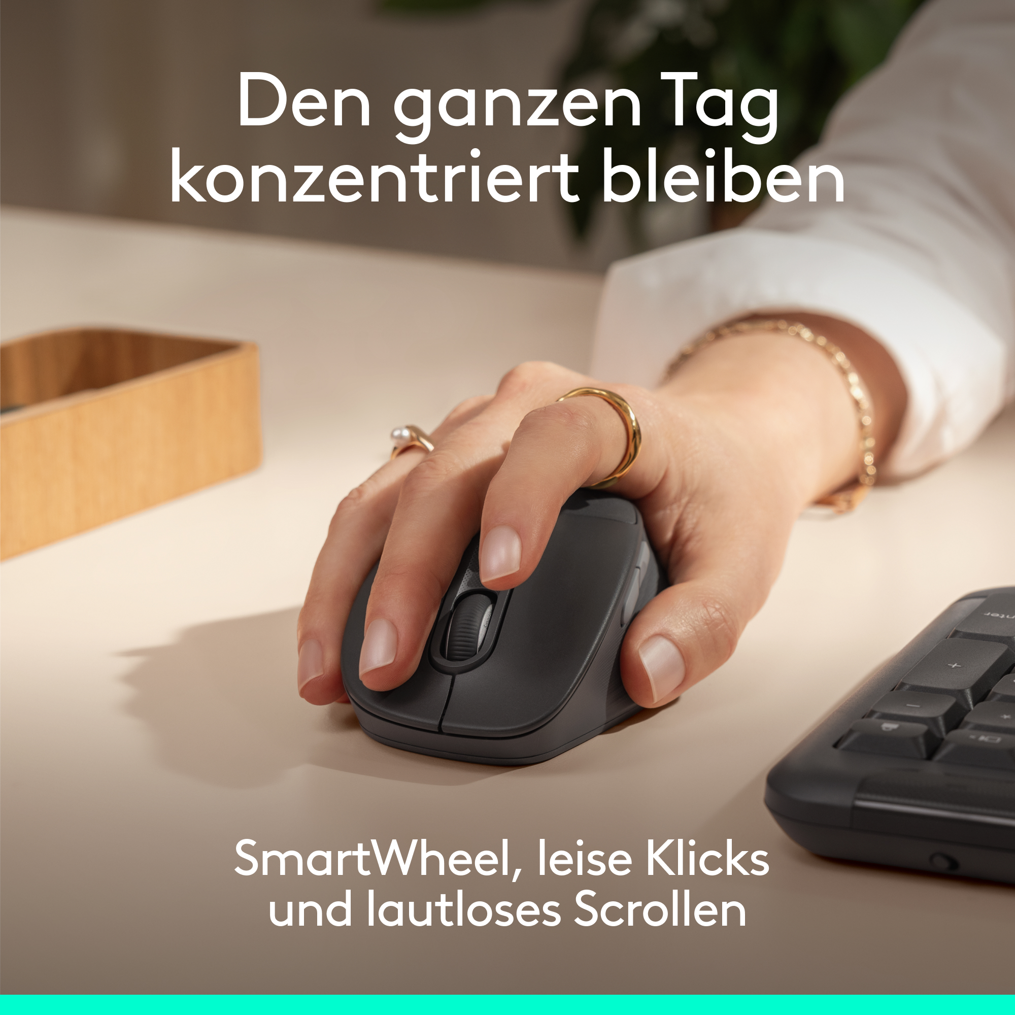 Person benutzt eine kabellose Maus und Tastatur auf einem Schreibtisch.