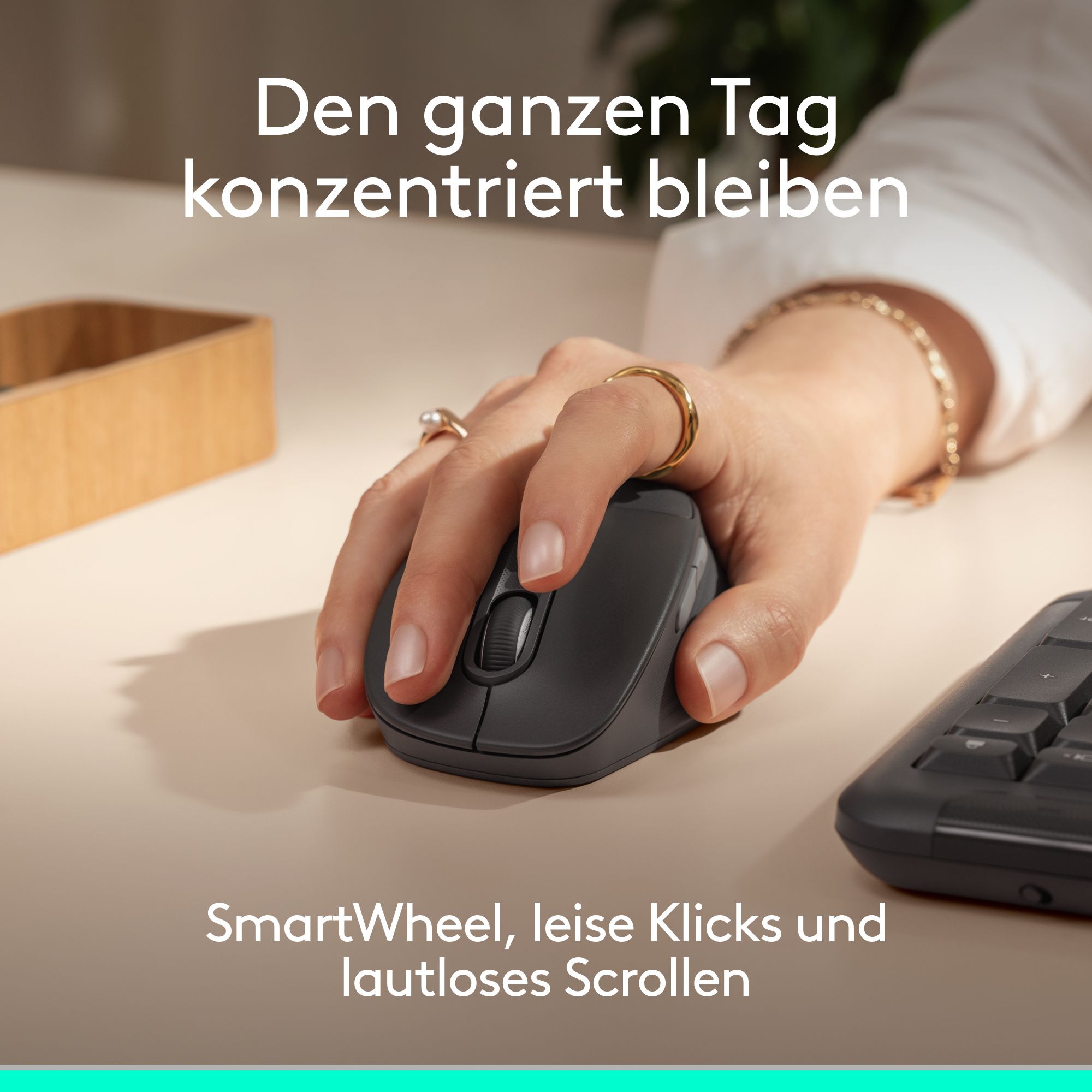 Eine Hand bedient eine dunkle Maus auf einem hellen Schreibtisch.