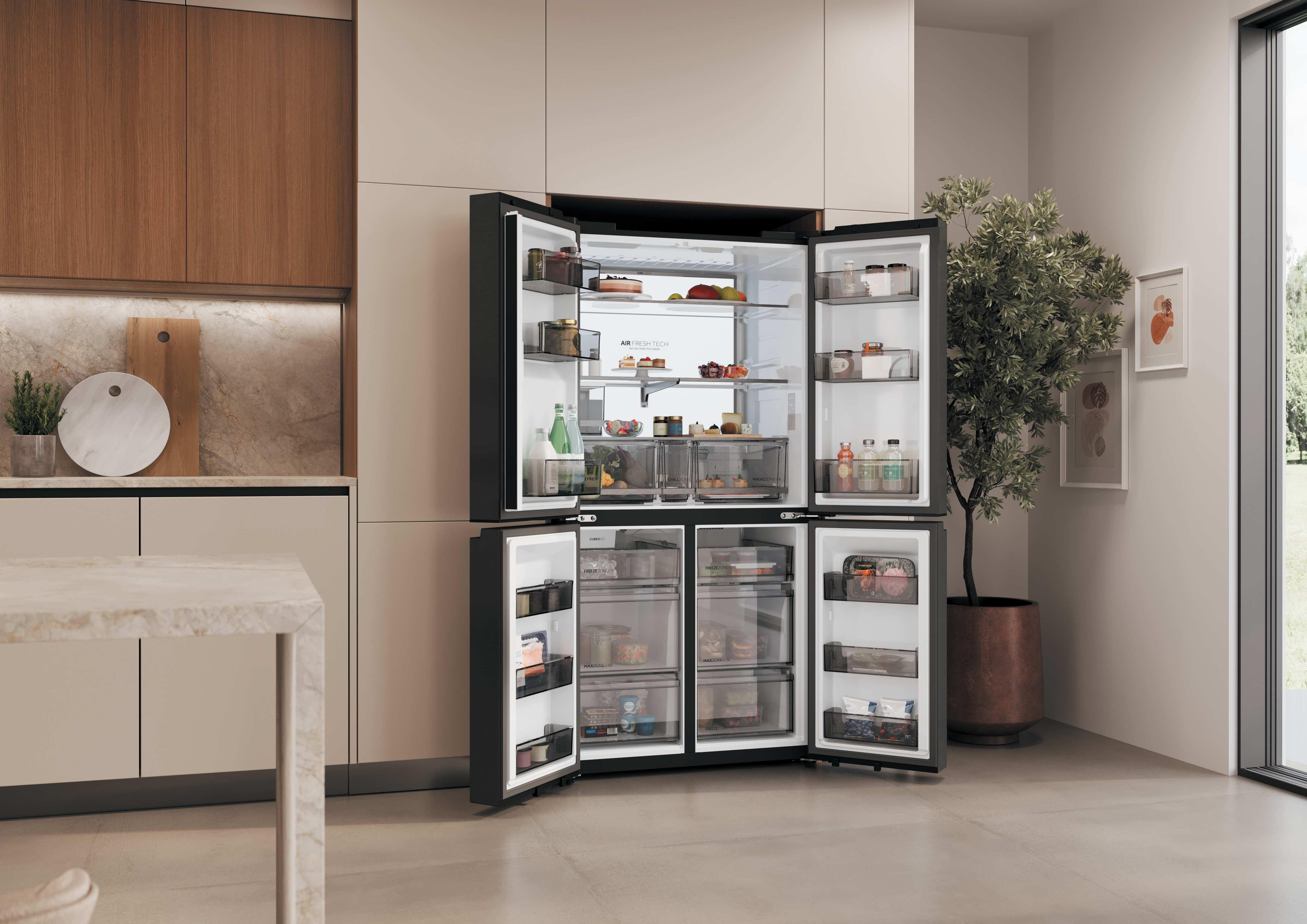 Ein offener schwarzer Kühlschrank mit Lebensmitteln und einem Baum daneben.