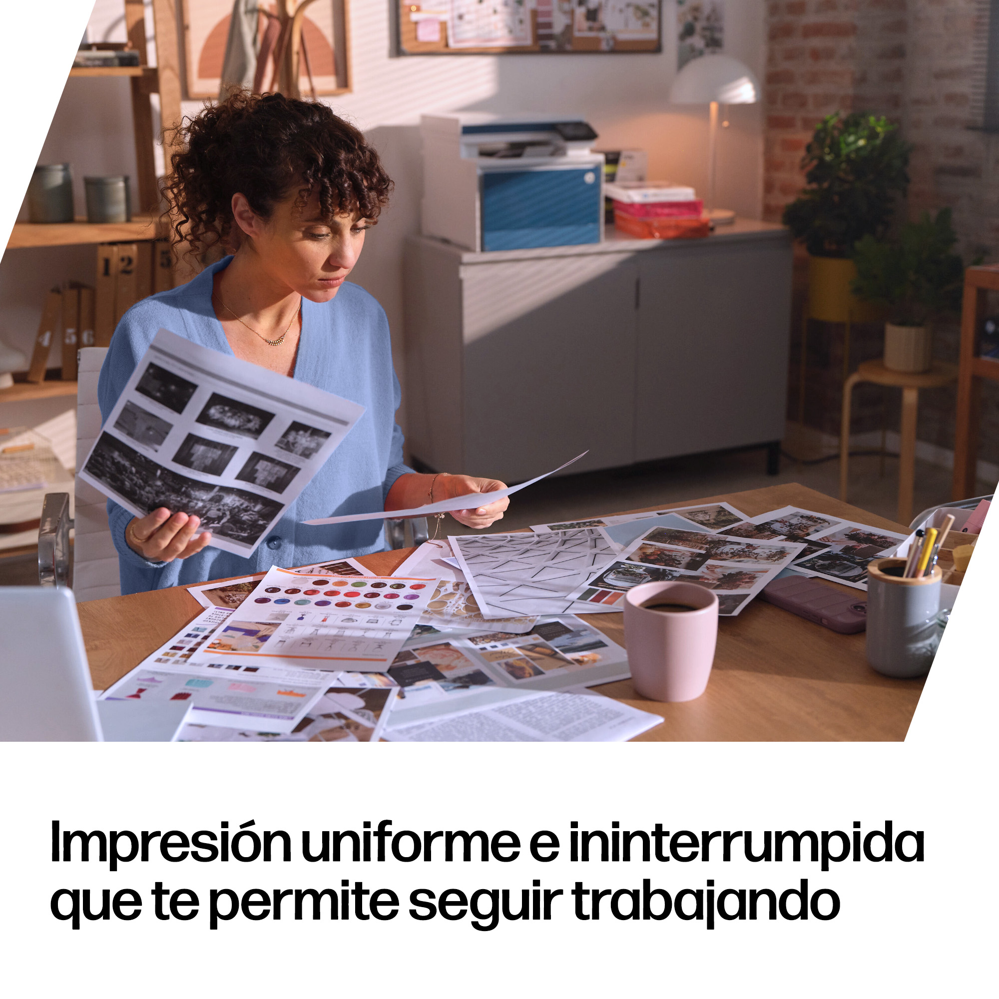 Una mujer con cárdigan azul revisa documentos en un escritorio.