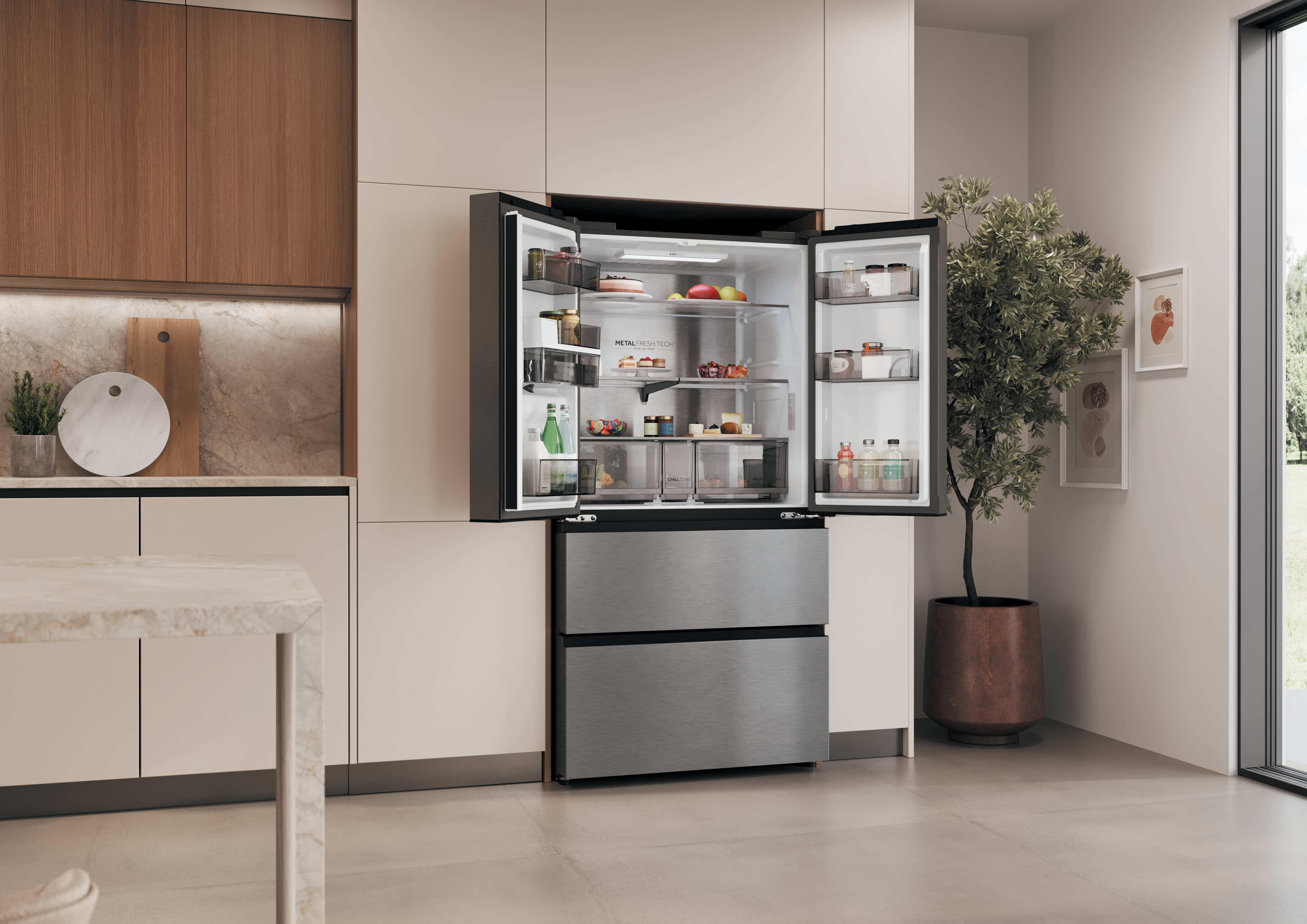 Ein offener Kühlschrank mit Lebensmitteln und eine Pflanze im Topf daneben.