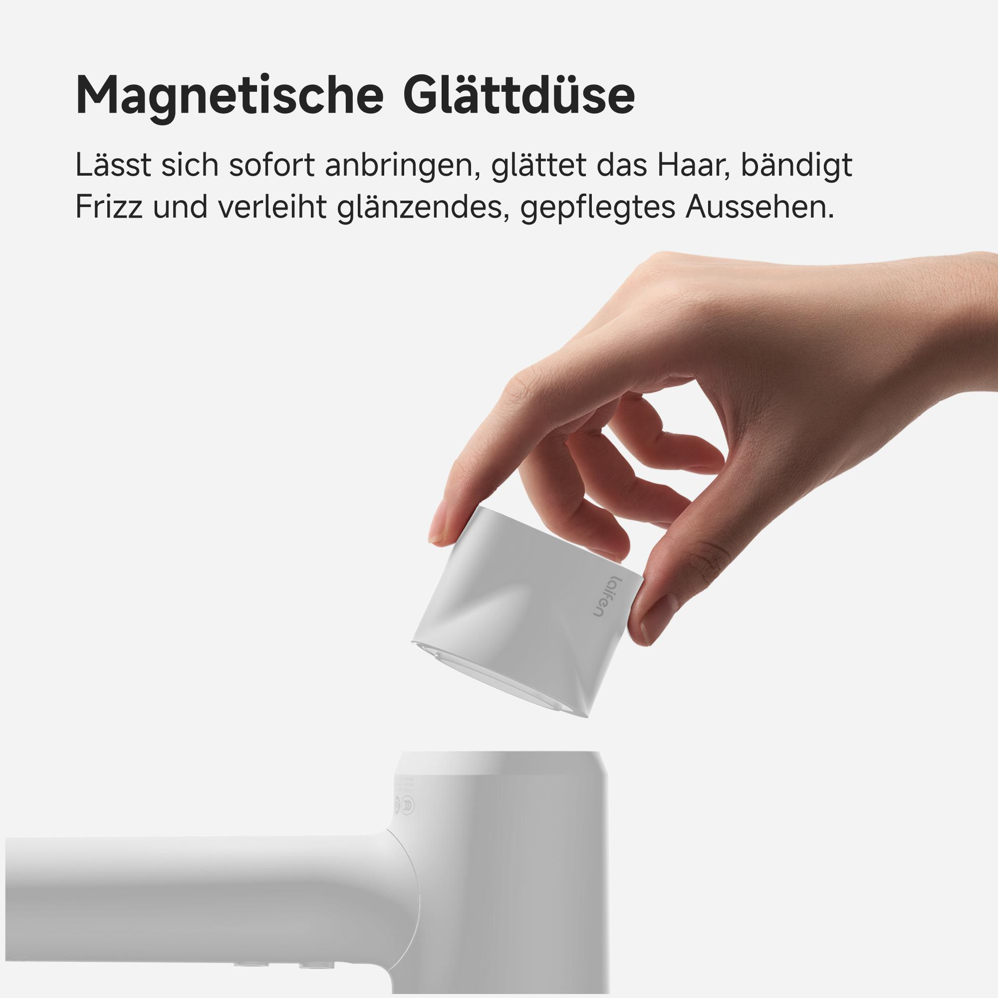 Eine Hand hält eine weiße Düse, die über einem Haartrockner befestigt wird.