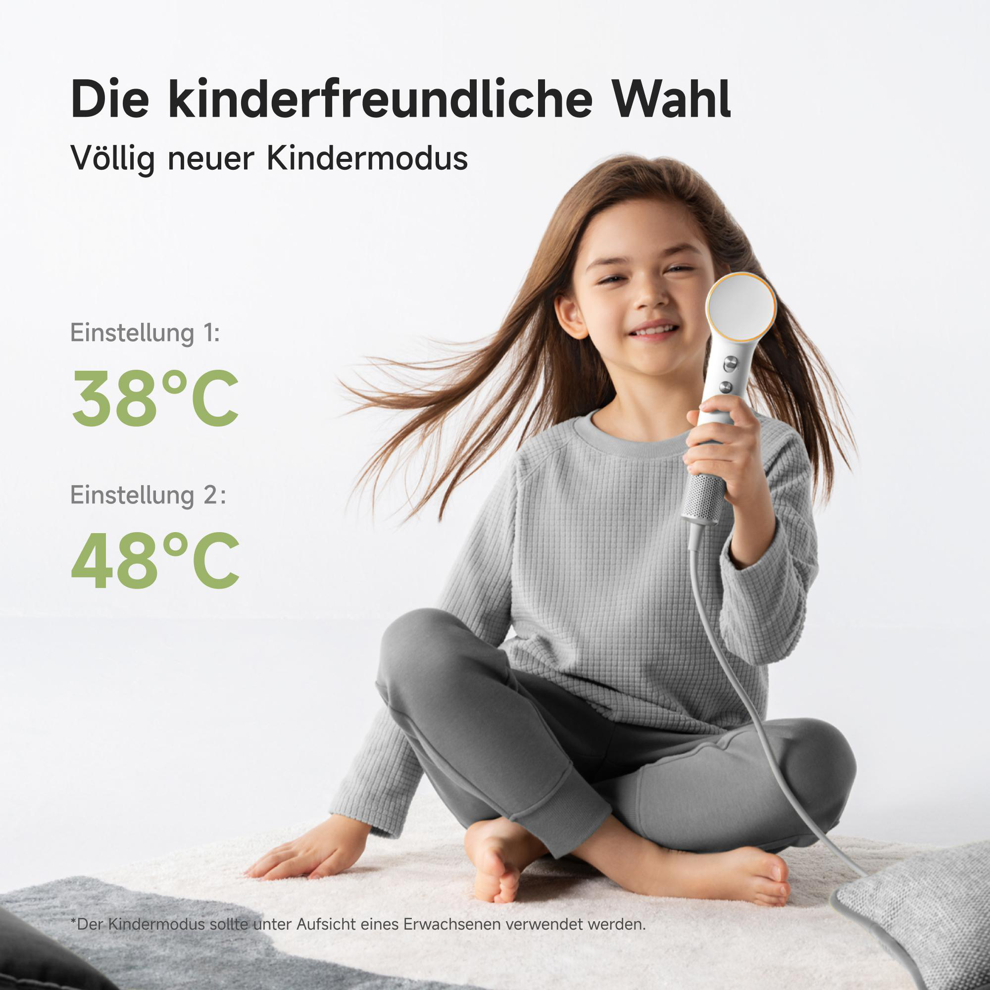 Ein Mädchen hält ein Gerät, das zwei Temperatureinstellungen anzeigt: 38°C und 48°C.
