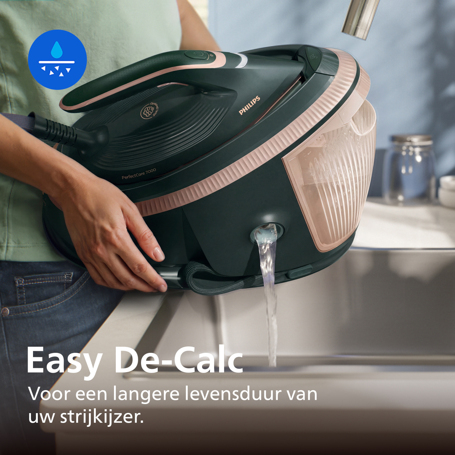 Steam iron being descaled. Water flows from the tank into a sink.