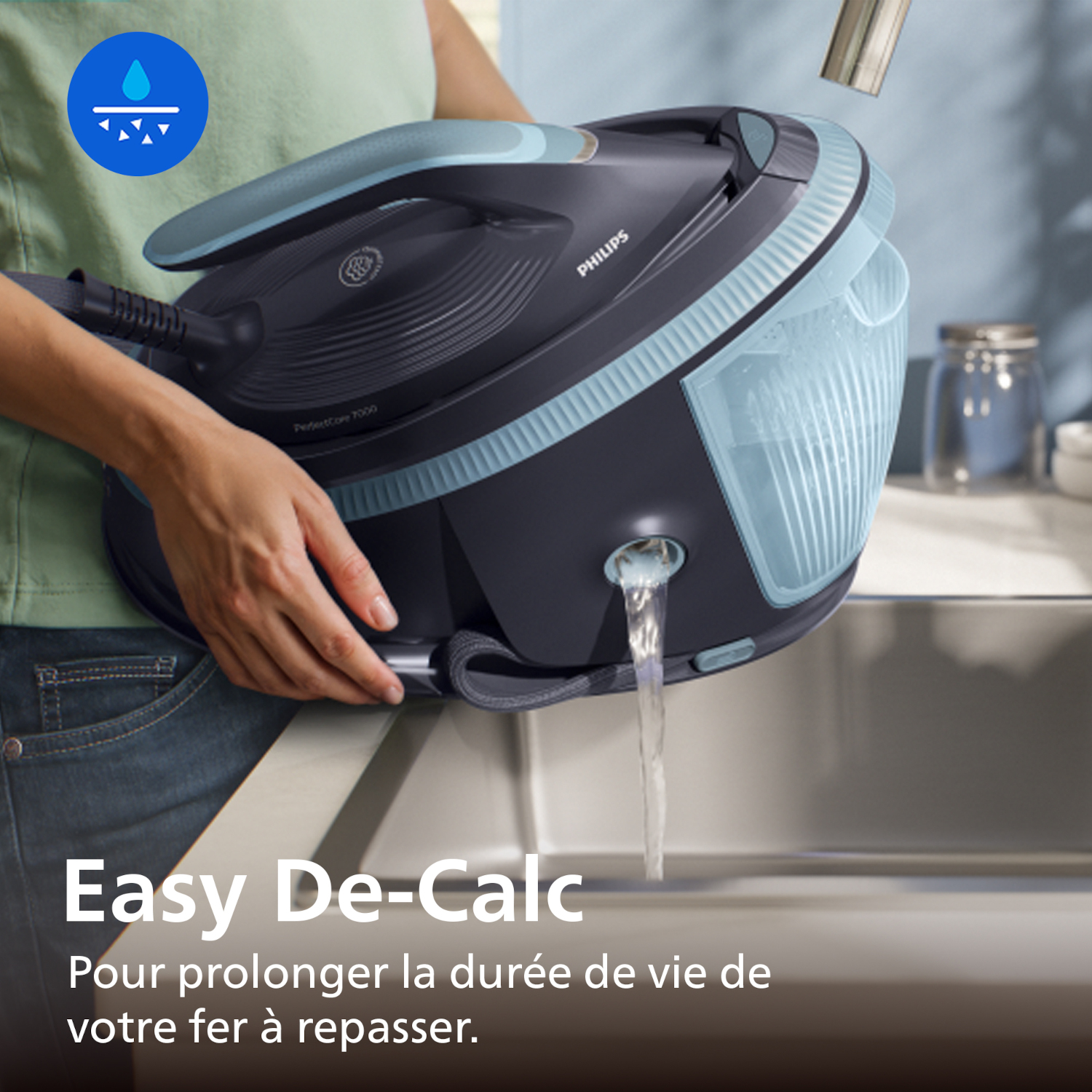 Une personne vide de l'eau d'un fer à vapeur dans un évier.
