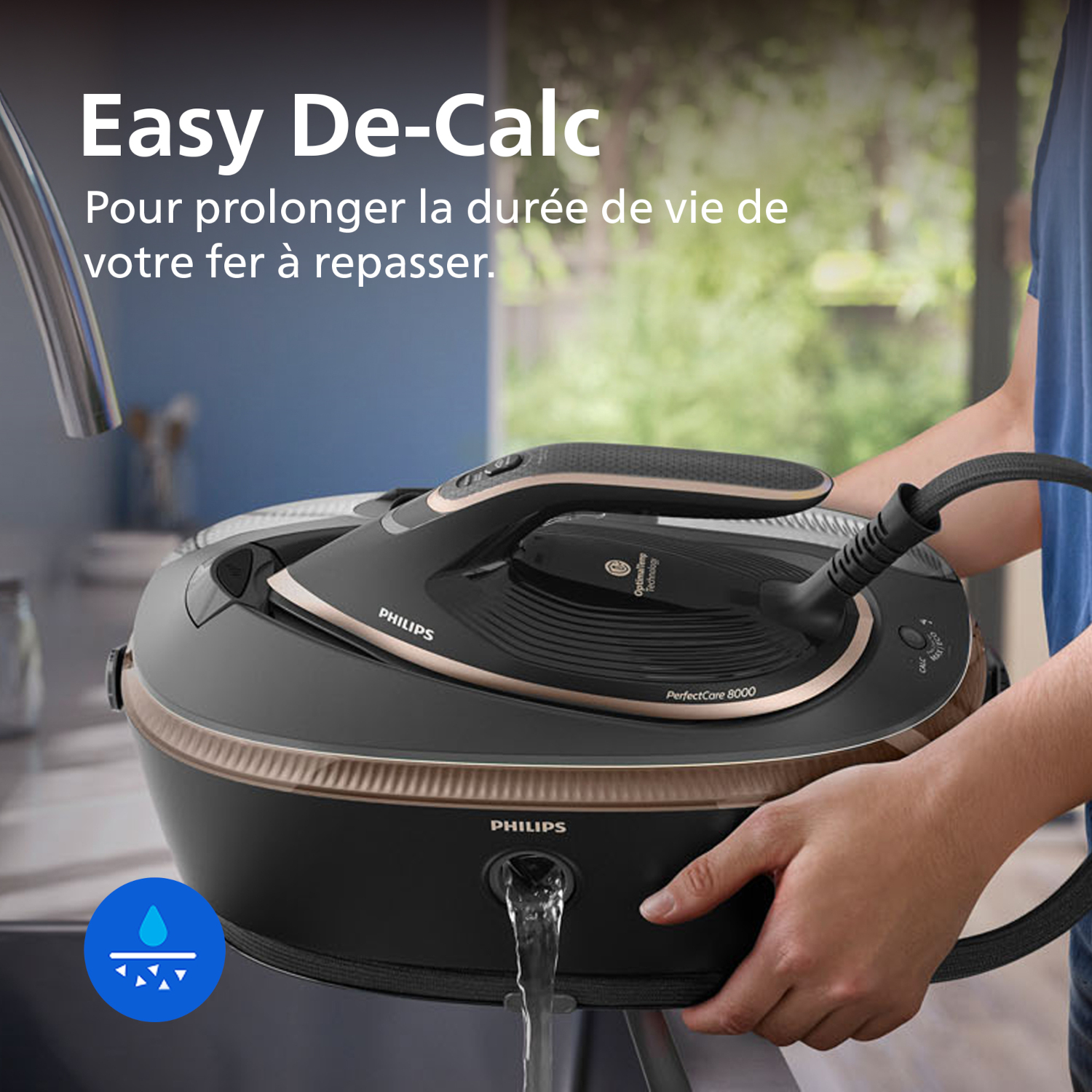 Une personne remplit une centrale vapeur Philips noire aux accents dorés.