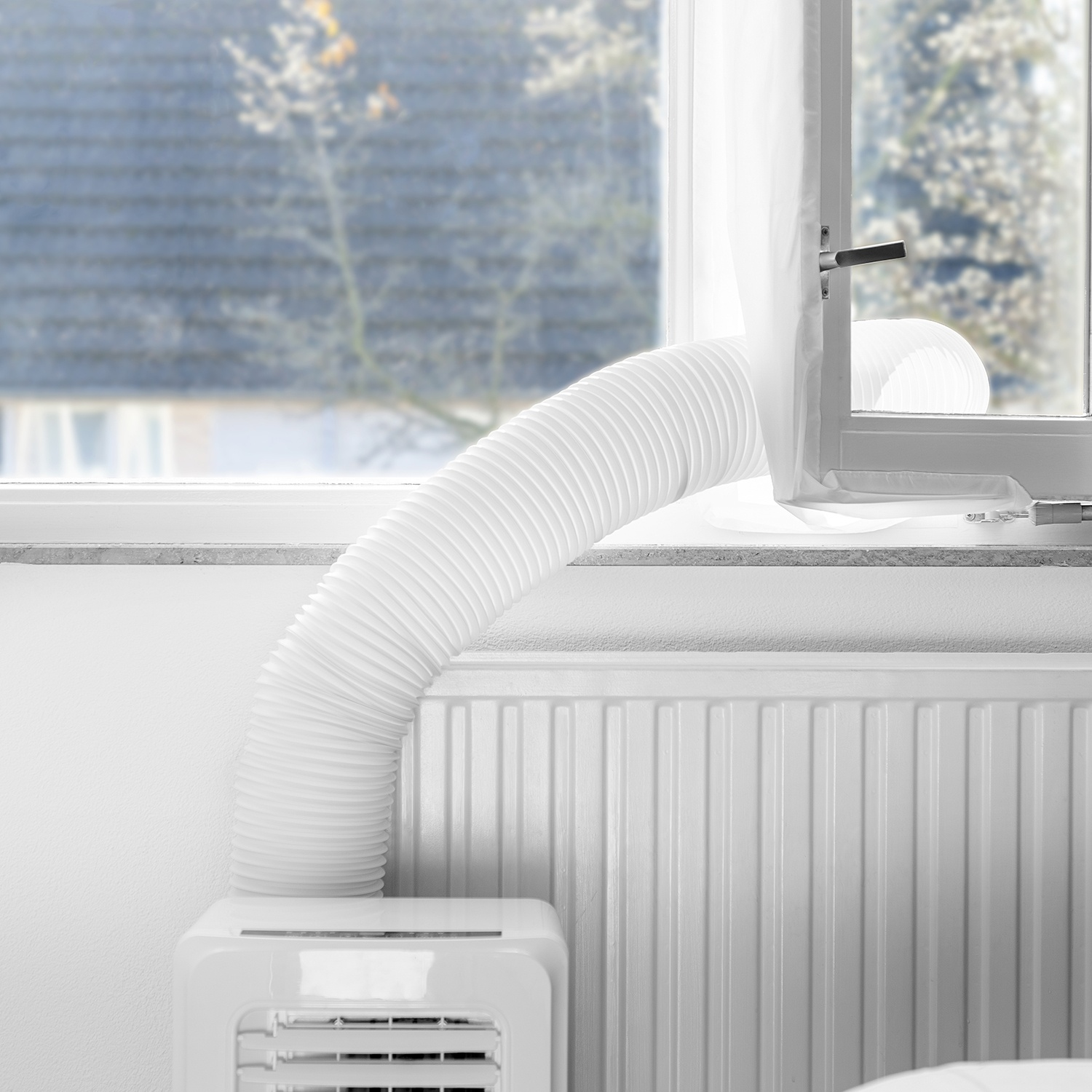 A white hose leads from an air conditioner to a window.