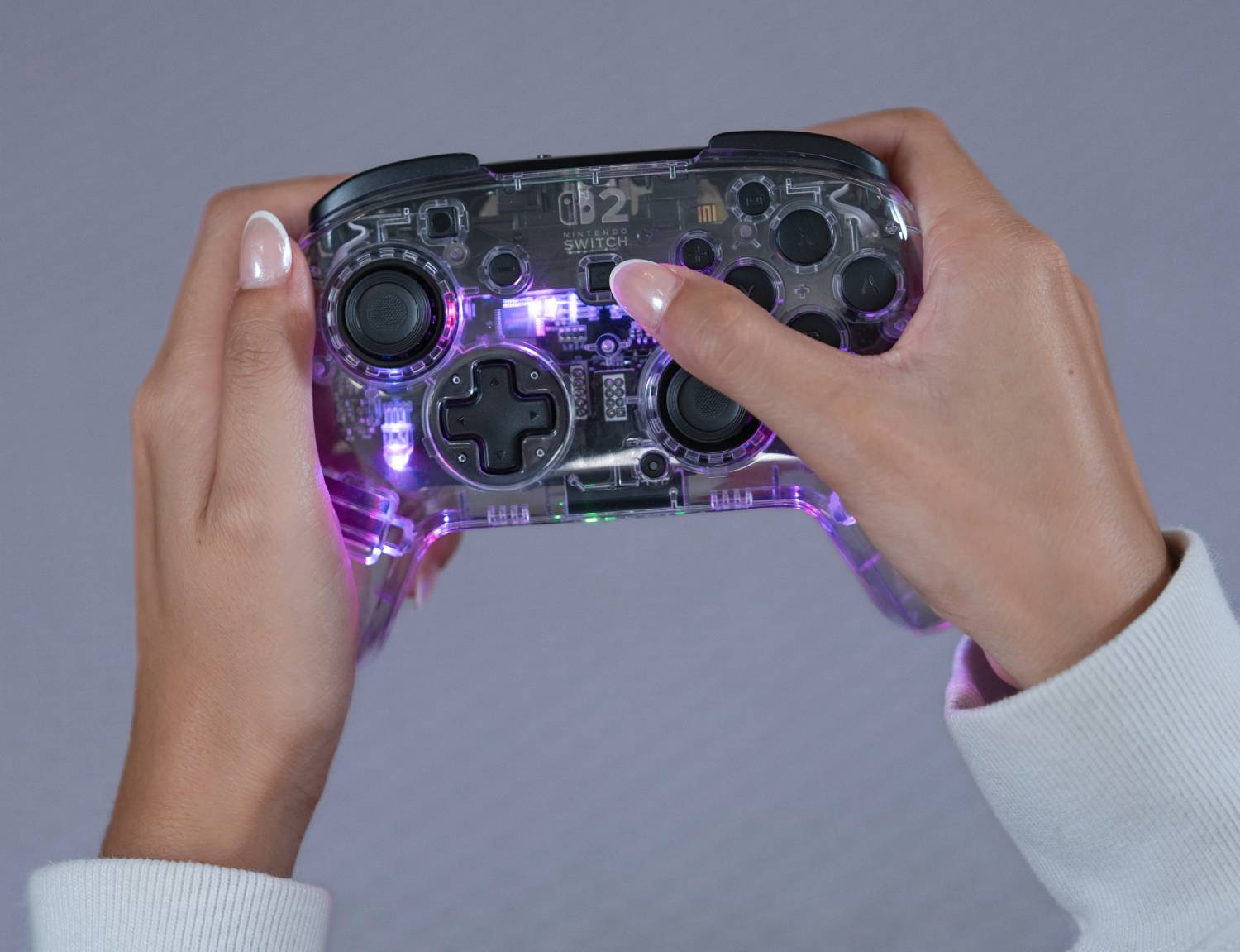 Controlador transparente con luces sostenido por manos.