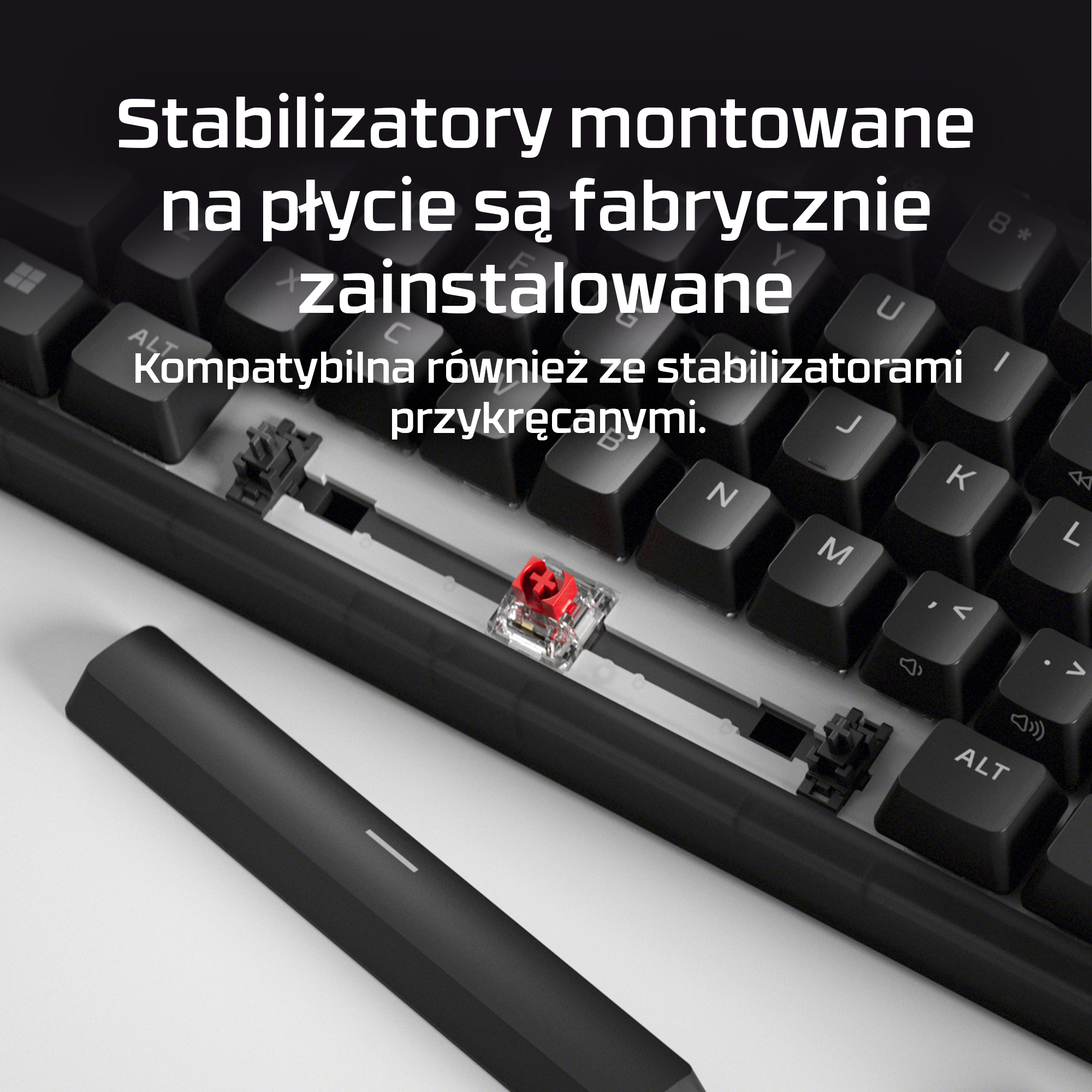 Zbliżenie czarnej klawiatury z odsłoniętymi stabilizatorami i czerwonym przełącznikiem.
