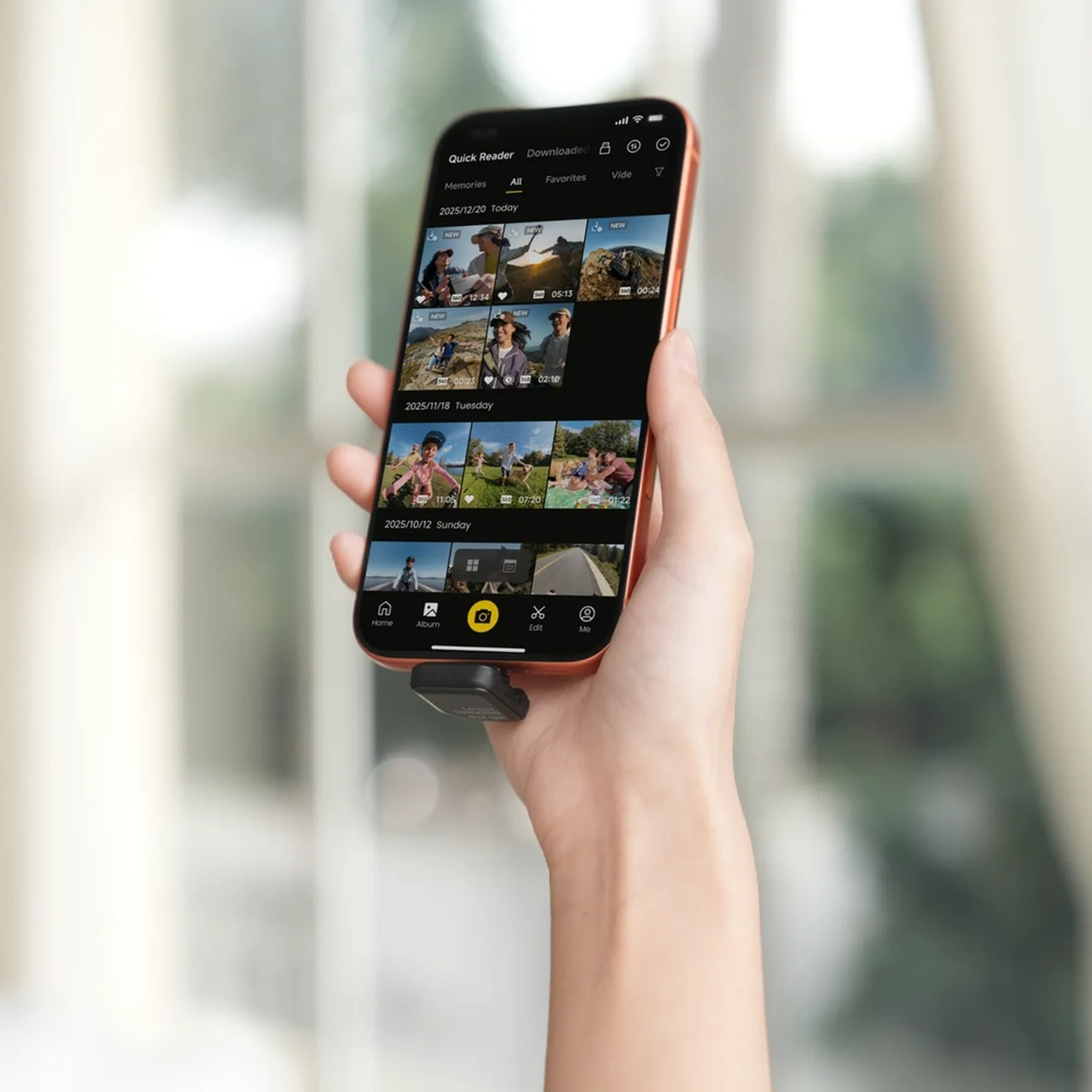 Mano tiene telefono con app foto. Viene visualizzato elenco foto.