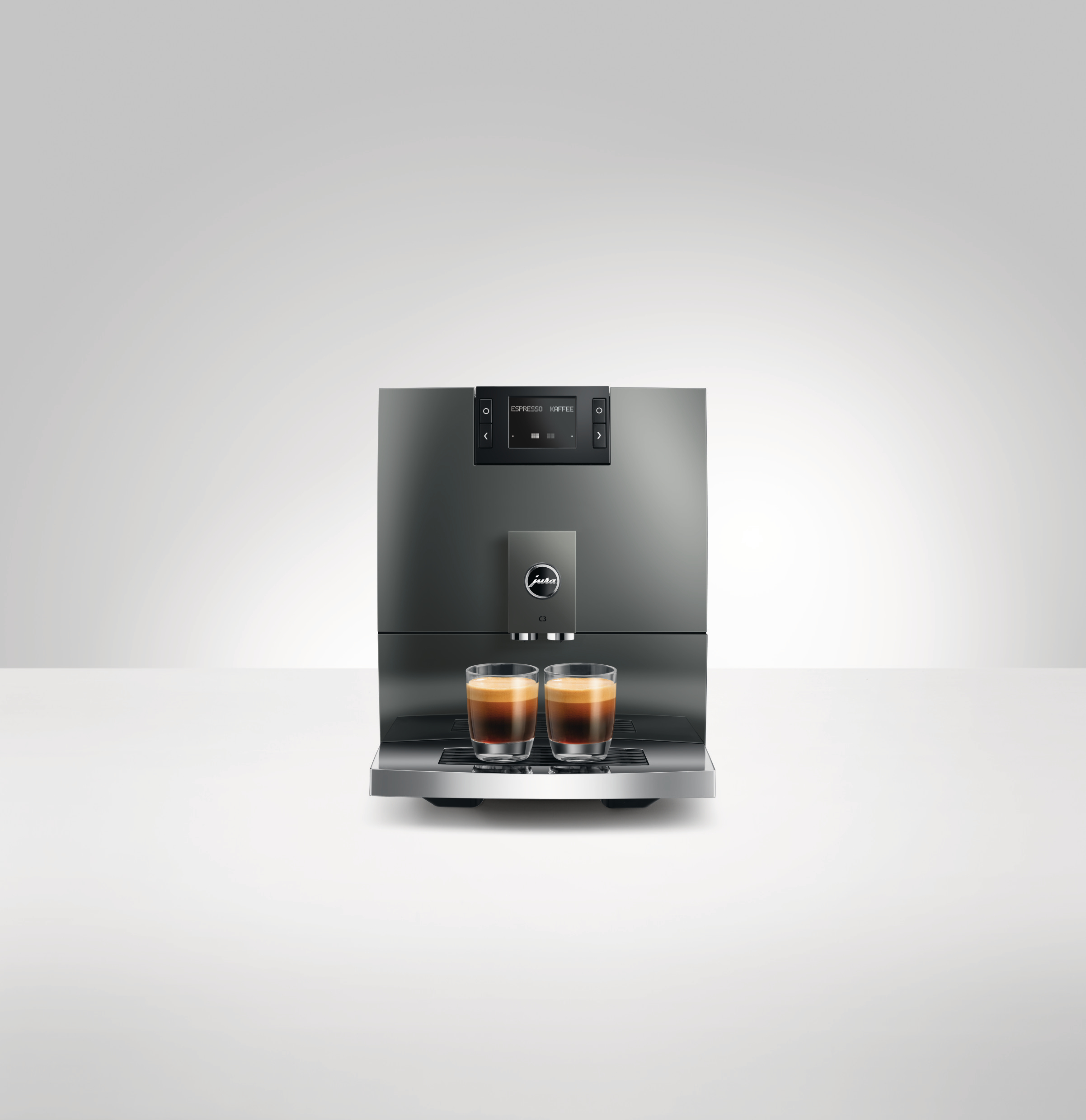 Ein moderner, grauer Kaffeevollautomat mit zwei Tassen Espresso.
