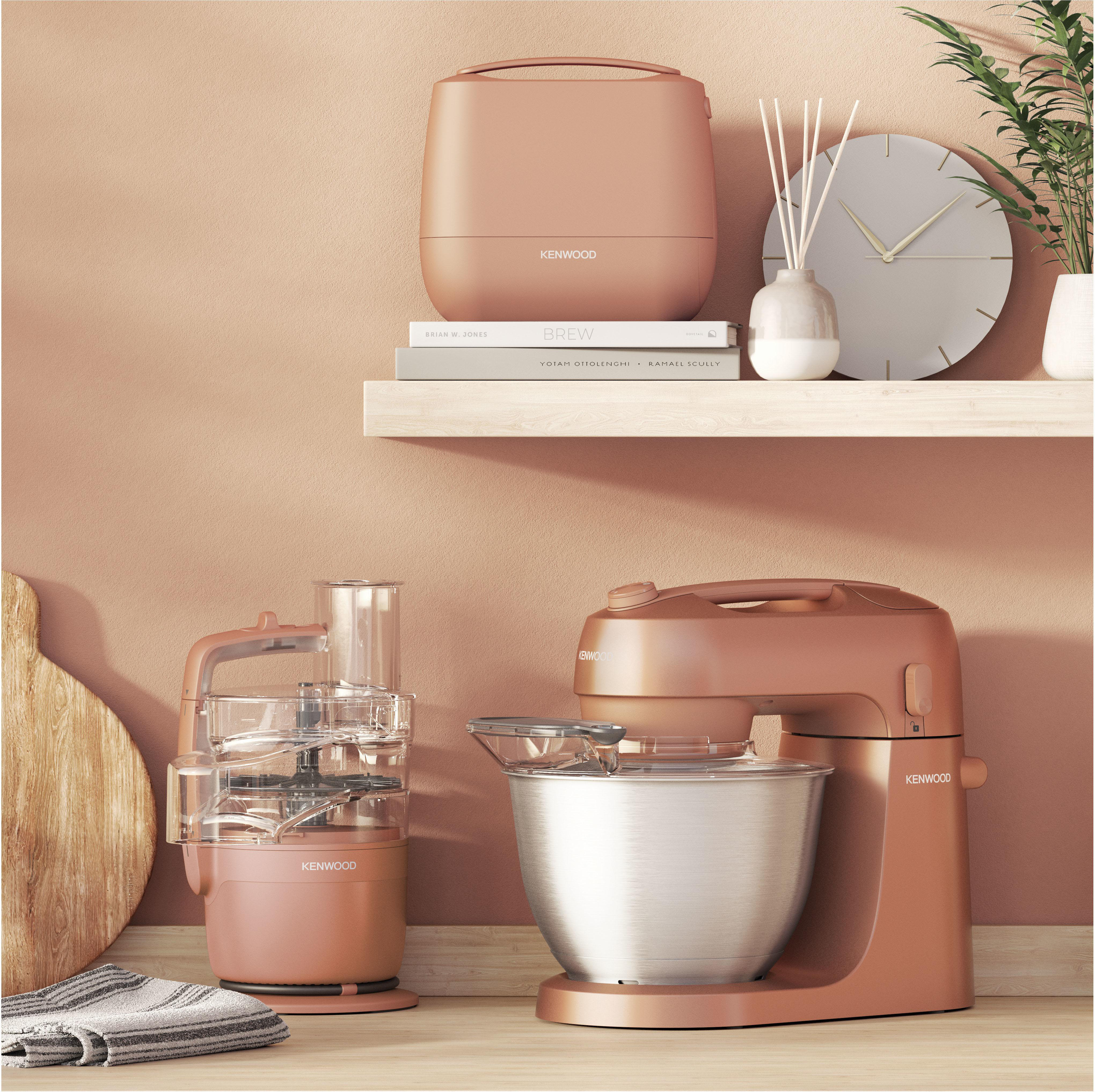 Küchenmaschinen und ein Food Processor in Roségold auf einem Holztresen.