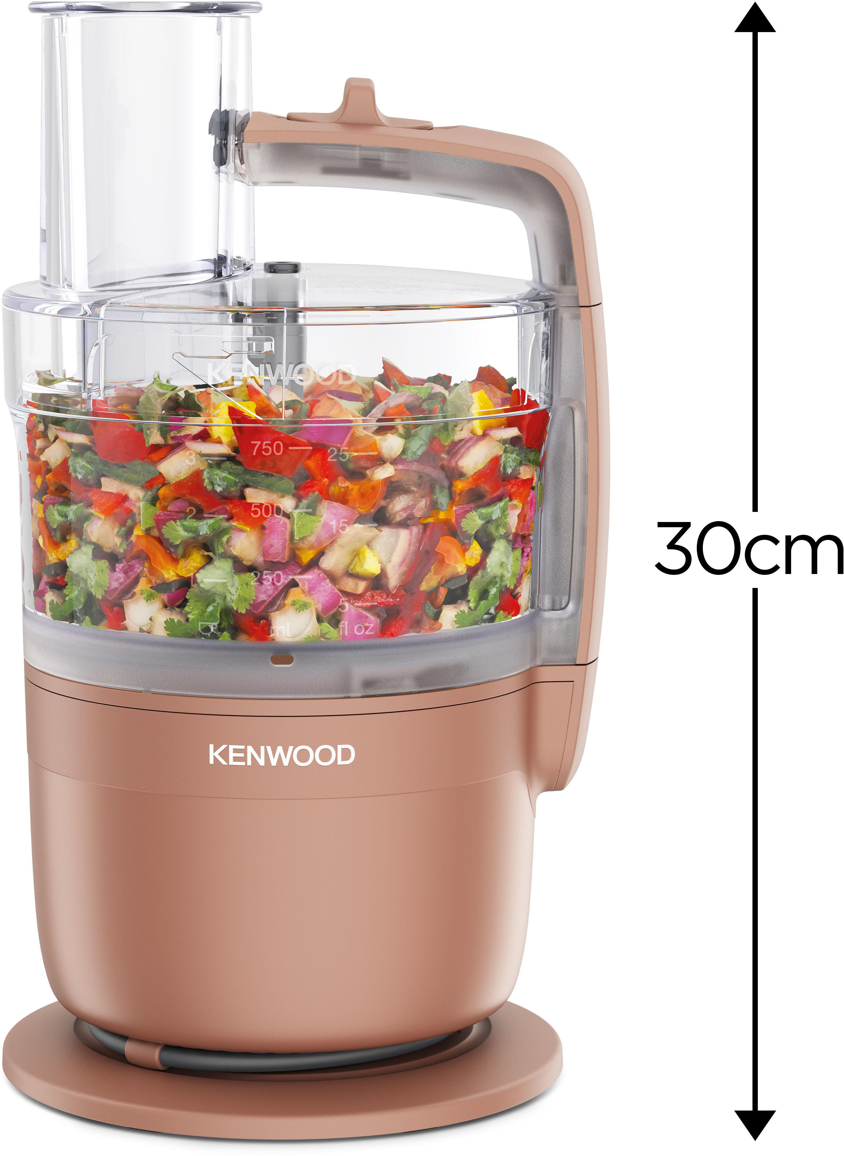 Eine Küchenmaschine in Roségold mit gehacktem Gemüse im Behälter.