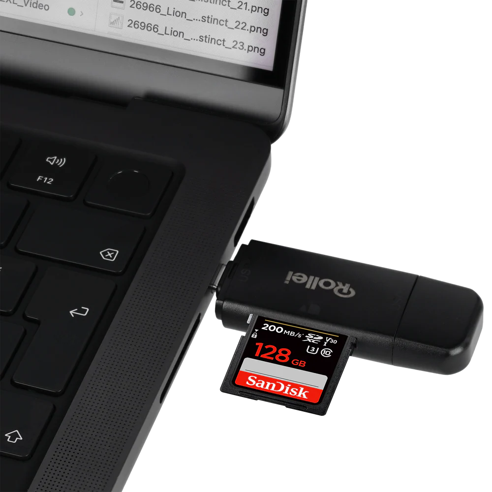 Un lecteur de carte SD noir est branché sur un ordinateur portable, avec une carte SD SanDisk de 128 Go insérée.
