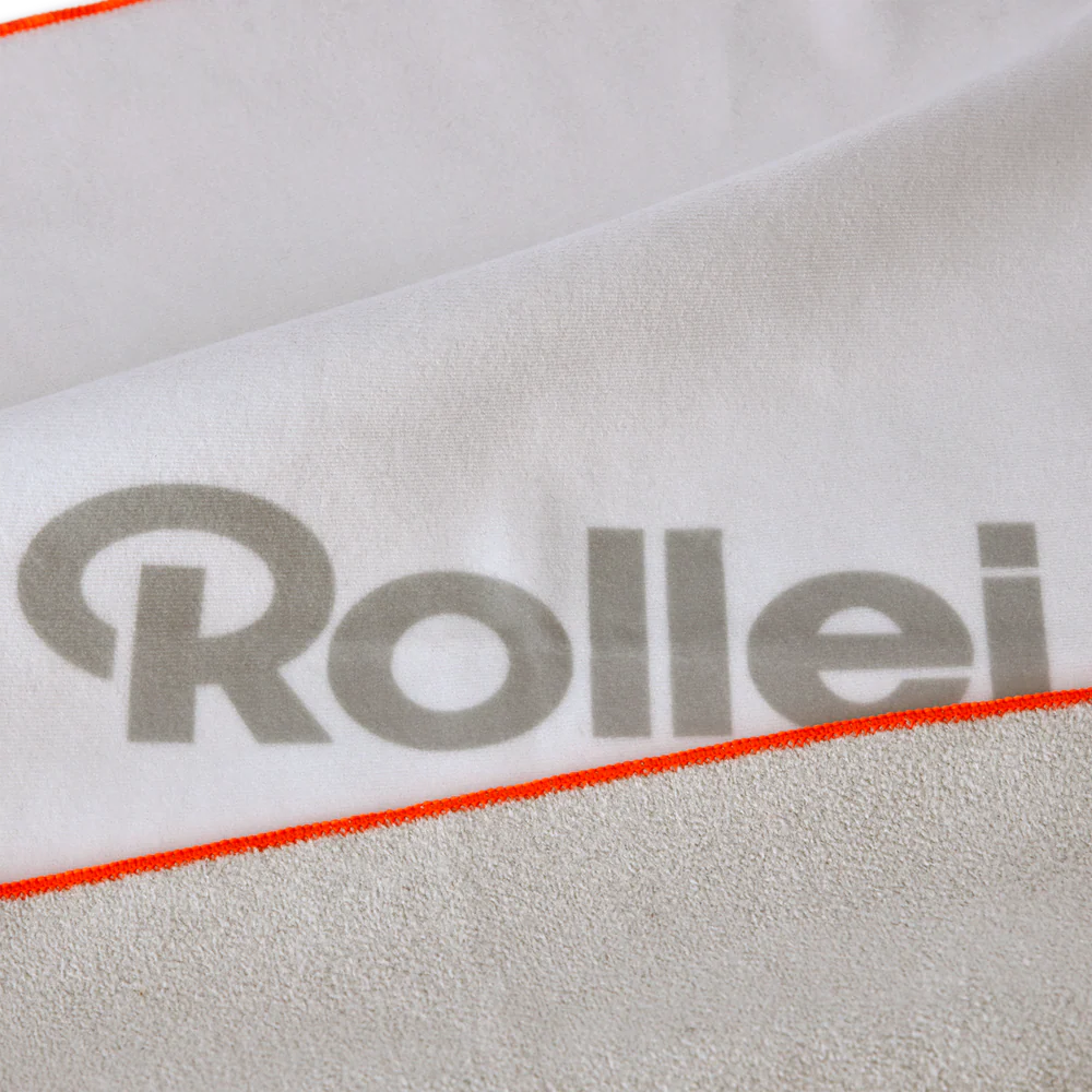 Weißes Handtuch mit orangefarbener Kante und grauem Rollei-Logo.