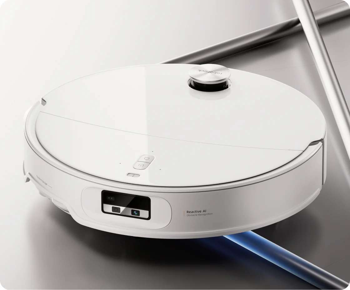 Un robot aspirapolvere bianco con torretta lidar e fotocamera frontale su pavimento grigio.