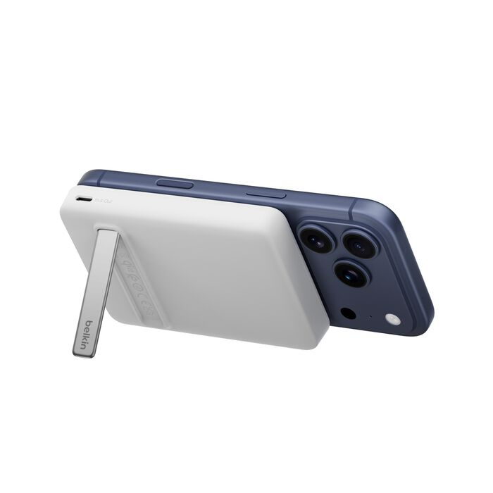 Un iPhone azul con una funda blanca que actúa como soporte.