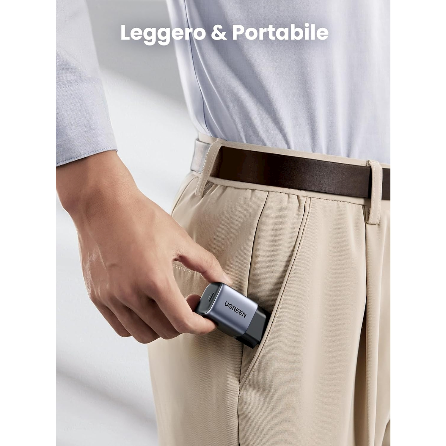 Una mano inserisce un piccolo caricatore grigio nella tasca di un pantalone kaki.