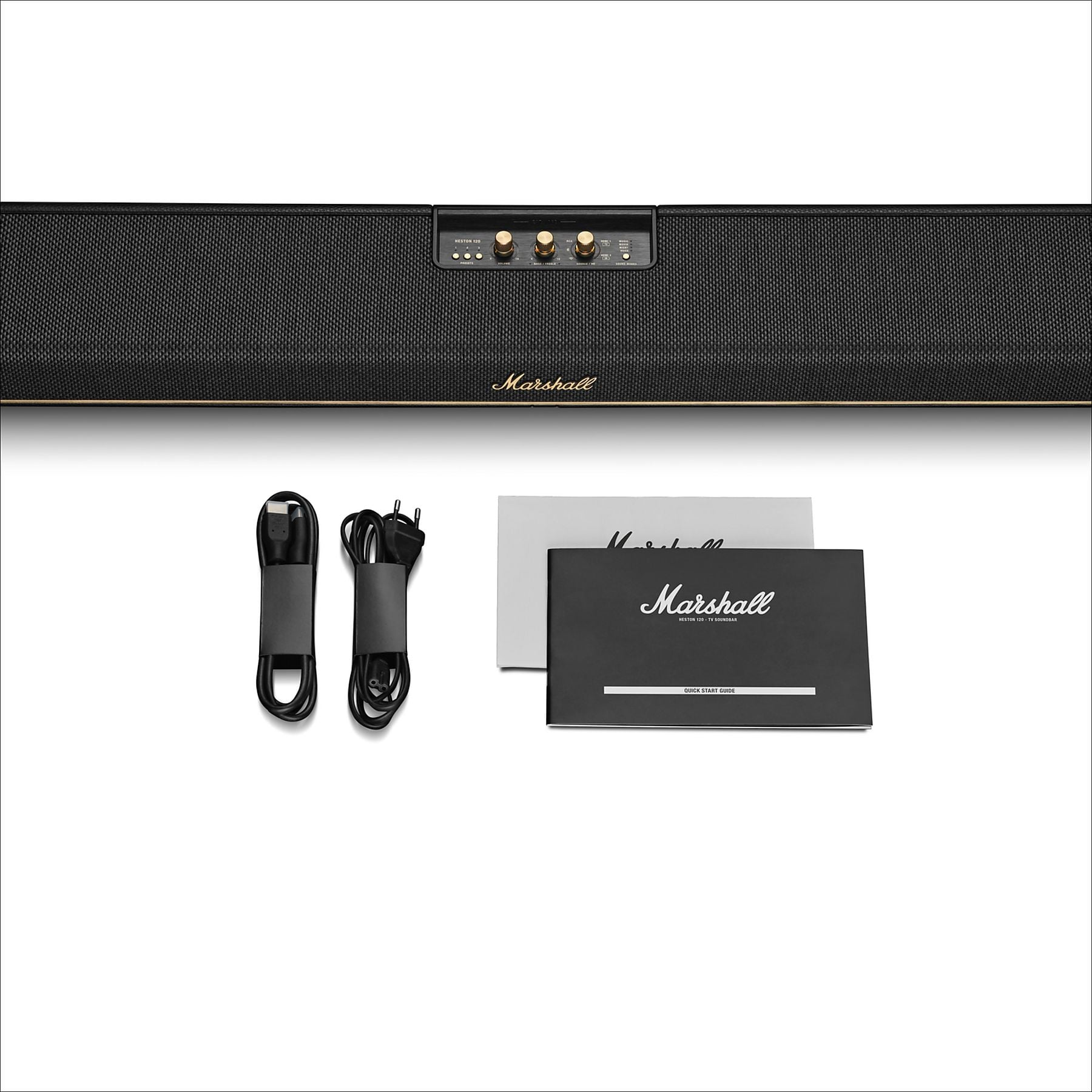 Una barra de sonido Marshall con cables y manual sobre fondo blanco.
