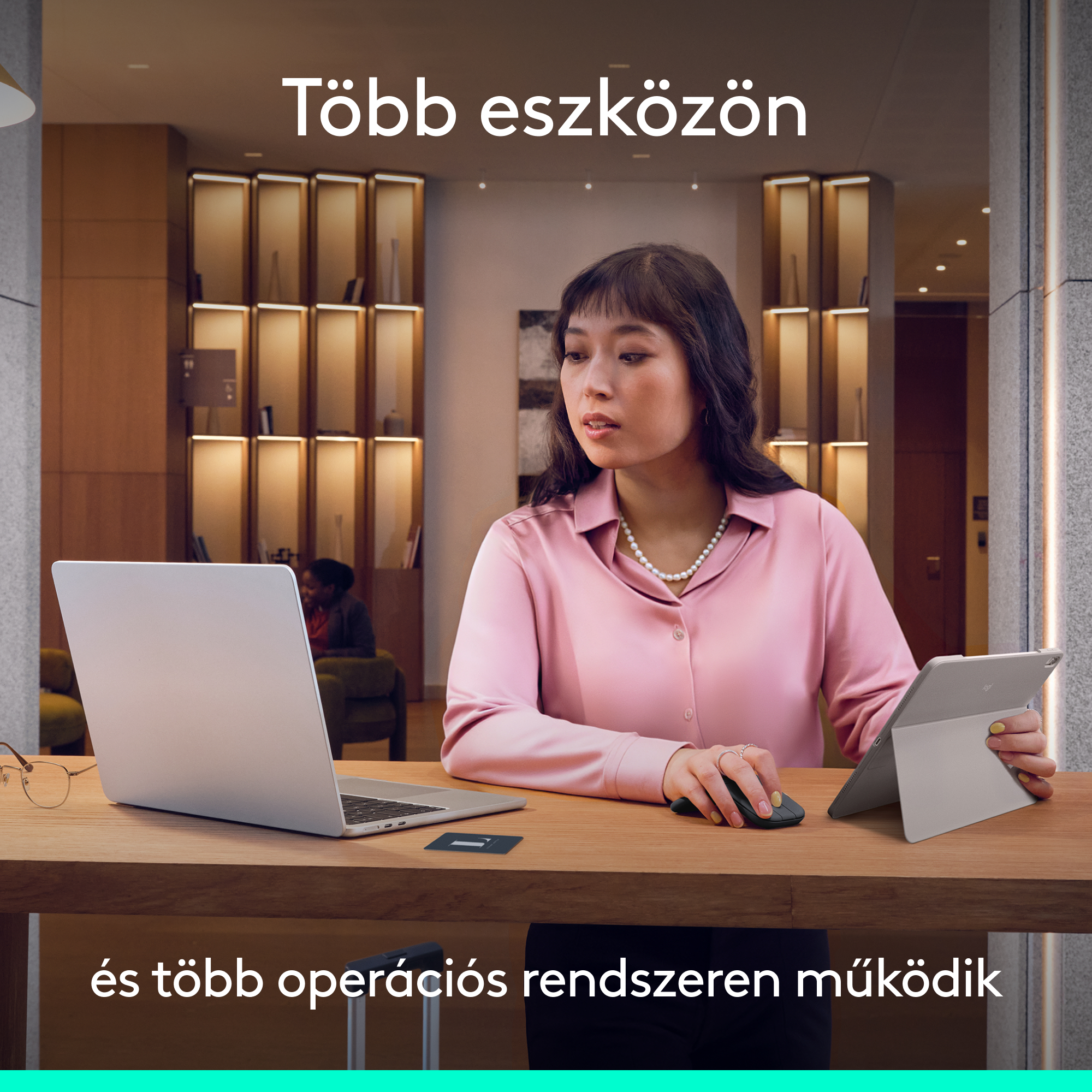 Egy nő dolgozik laptopon és tableten egy modern irodában.