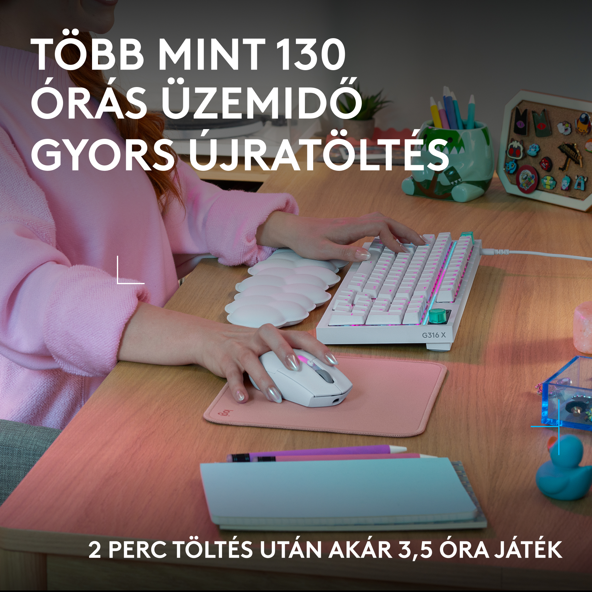 Egy személy fehér billentyűzeten gépel rózsaszín világítással. Fehér egér rózsaszín padon.