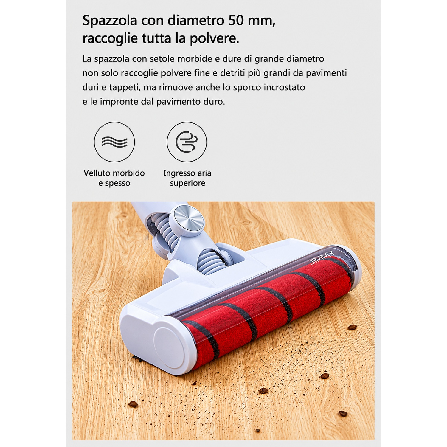 Accessorio aspirapolvere con spazzola rossa su pavimento in legno con detriti.