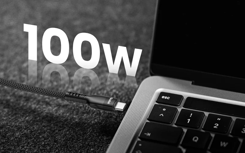 Ein USB-C-Kabel wird in einen Laptop gesteckt. "100W" steht groß daneben.