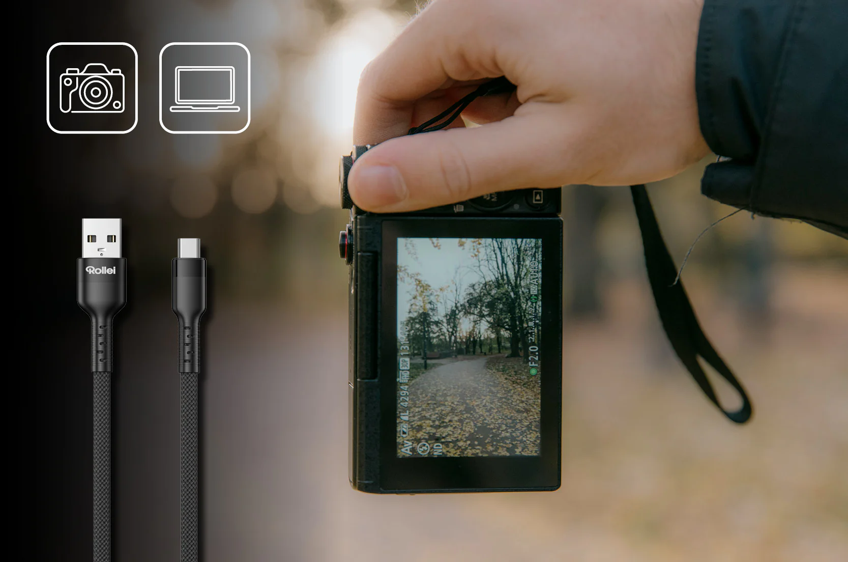 Nahaufnahme von zwei schwarzen USB-C-Kabeln und einer Kamera, die eine herbstliche Landschaft aufnimmt.