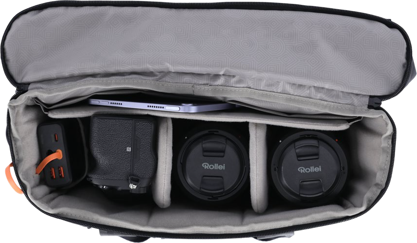 Un sac photo noir ouvert montre un appareil photo, deux objectifs, une tablette et un chargeur.