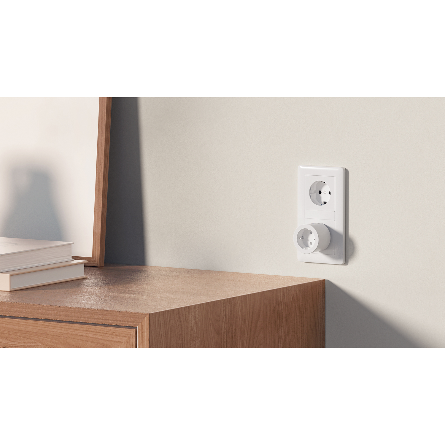 Een witte stekkeradapter in een stopcontact aan een crèmekleurige muur.