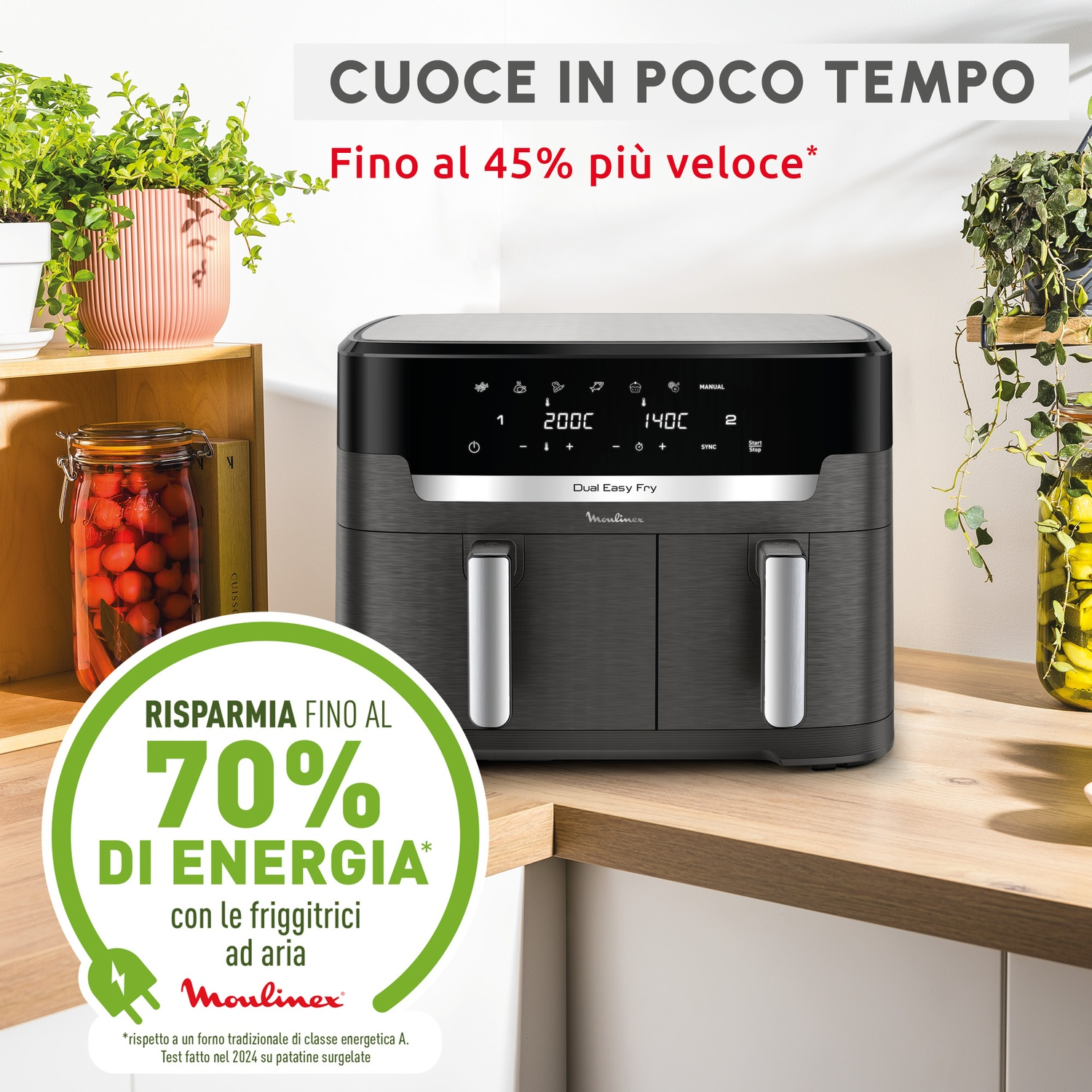 Una friggitrice ad aria scura a doppio scomparto su un bancone. Piante a sinistra e a destra.